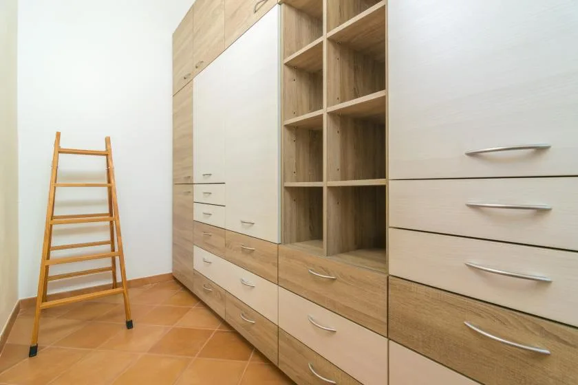 Una pared de almacenamiento empotrada con estantes abiertos y cajones en una habitación luminosa.
