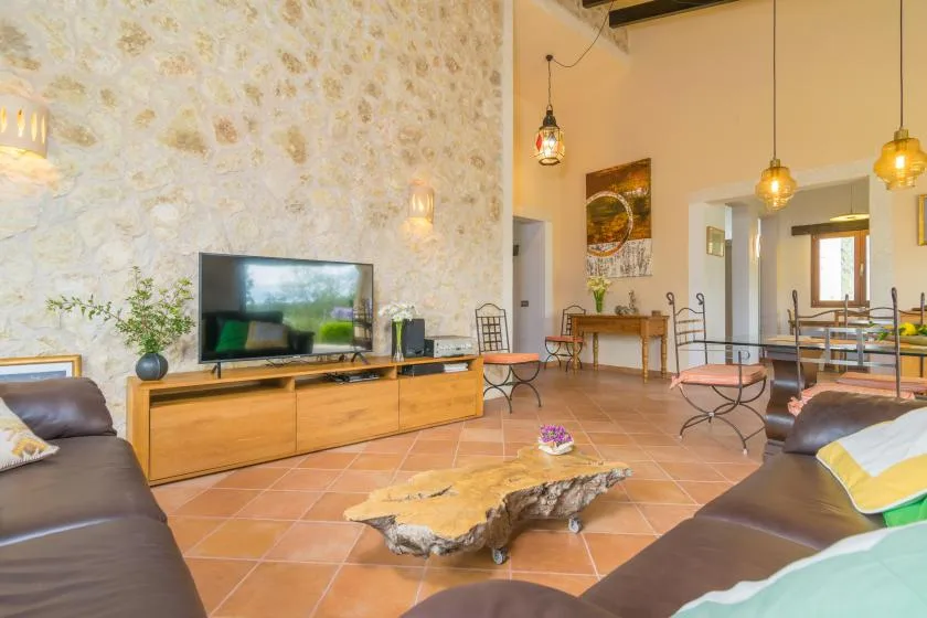Una amplia sala de estar con asientos, un televisor y una mesa baja de madera.