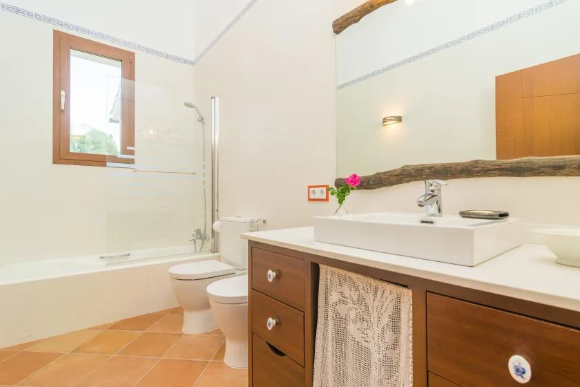 Un baño luminoso con bañera, inodoro y lavabo con mueble.