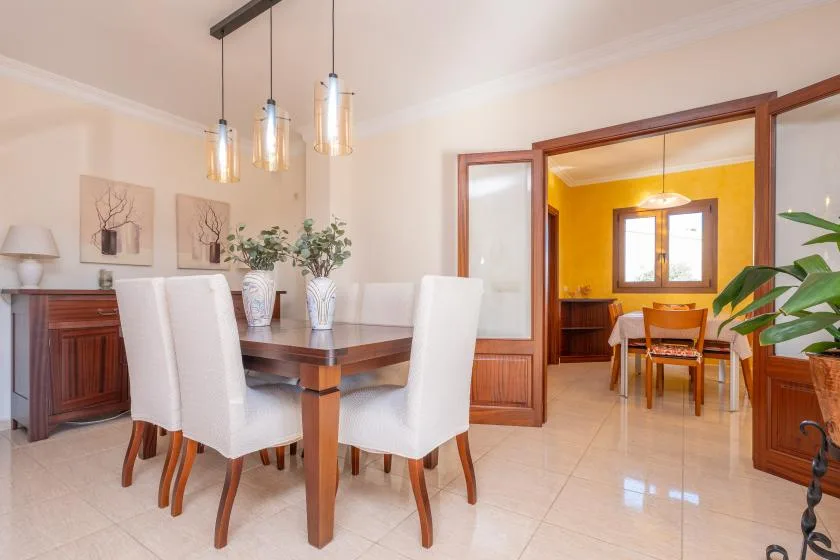 A dining room with a wooden table and light-colored seating.