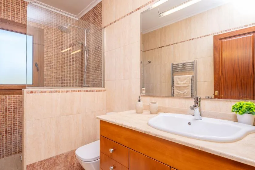 A bathroom with a vanity, sink, and glass shower enclosure.