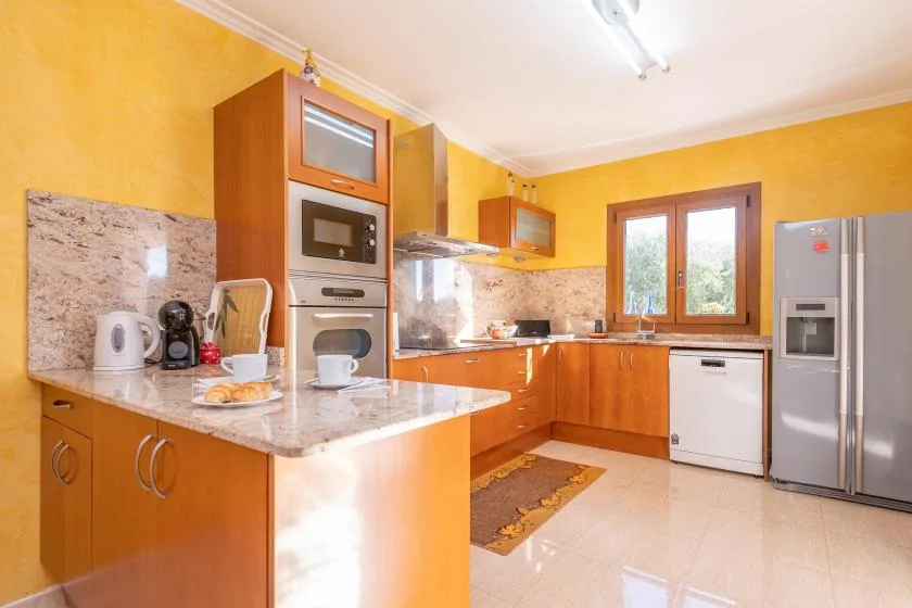 A bright kitchen with wooden cabinets, a countertop, and stainless steel appliances.