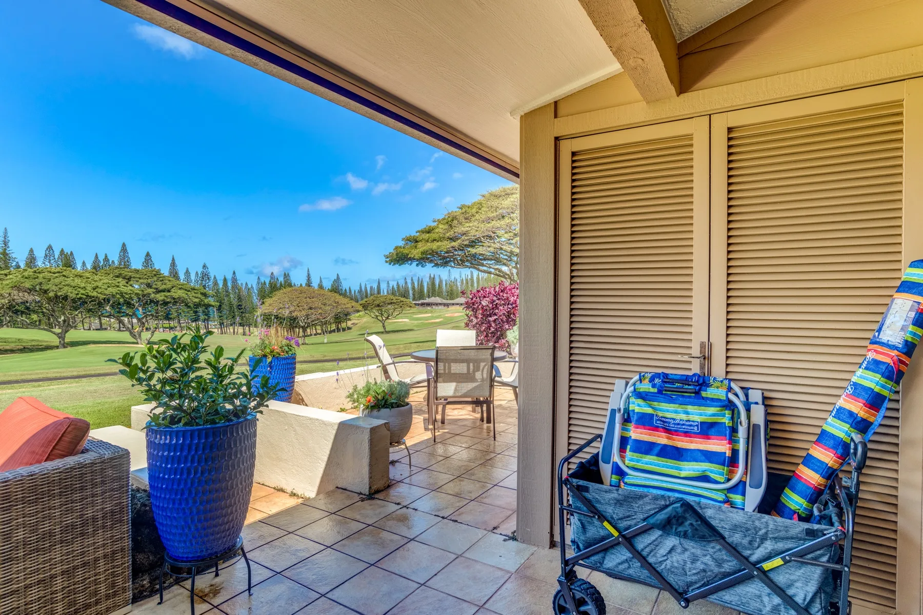 Un patio cubierto con asientos al aire libre y vistas a un paisaje verde.