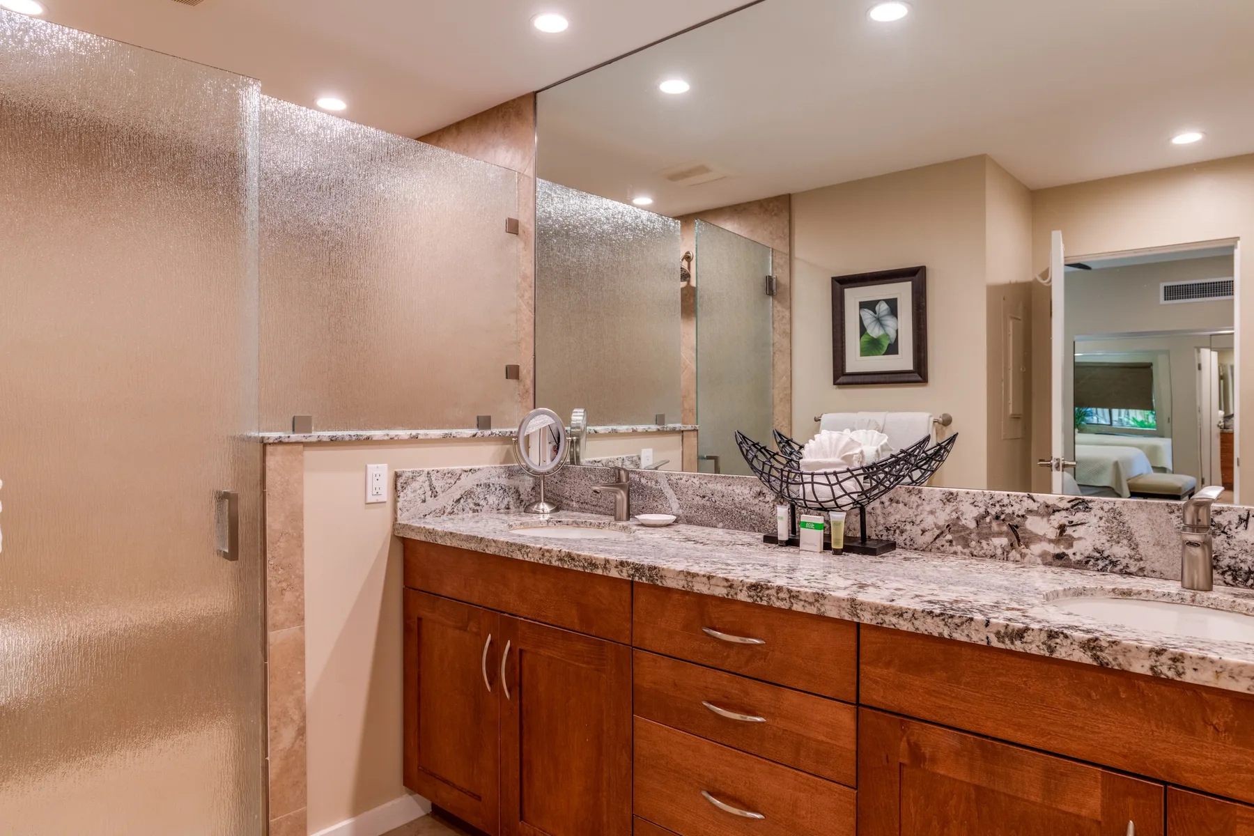 Un lavabo de baño con una amplia encimera de piedra y gabinetes de madera.