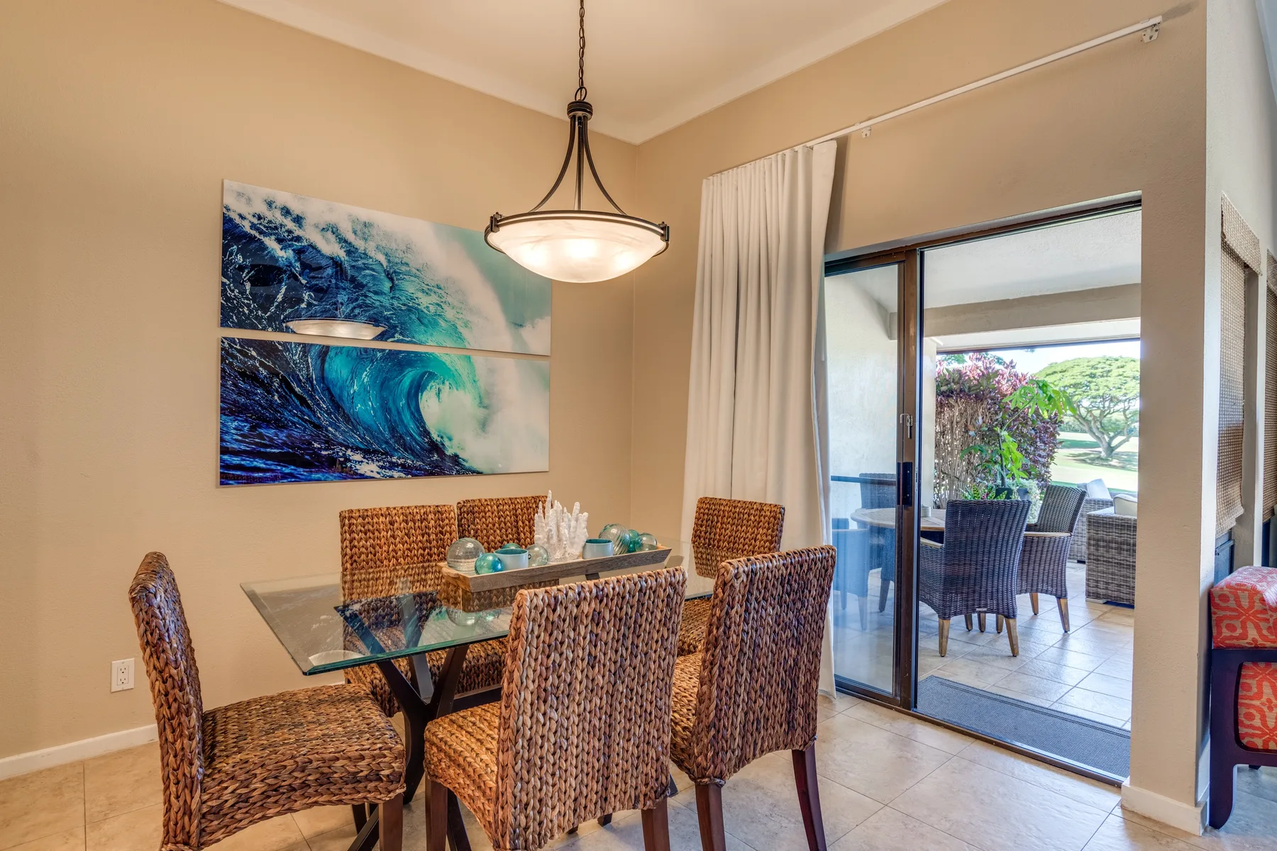 Comedor con una mesa de vidrio junto a puertas corredizas que dan a un patio.