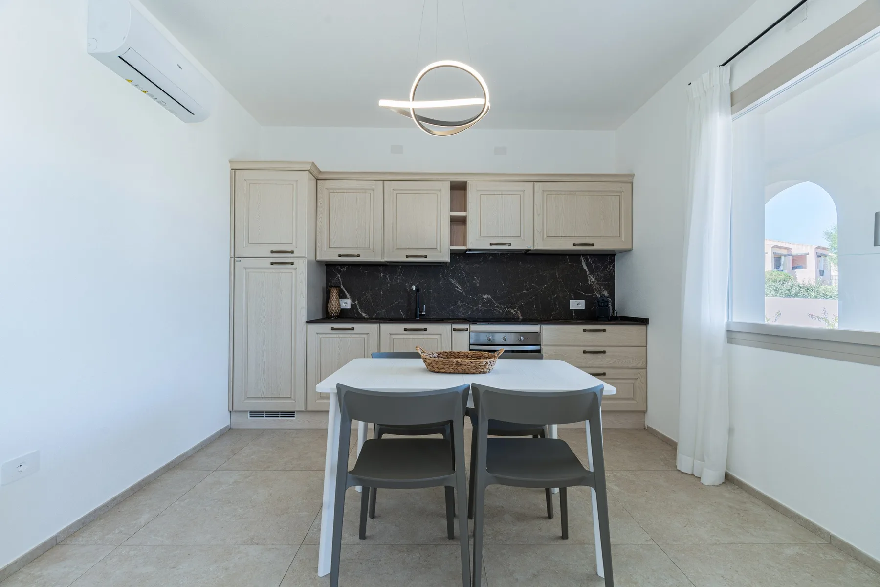 Una cocina luminosa con una mesa de comedor y armarios claros.