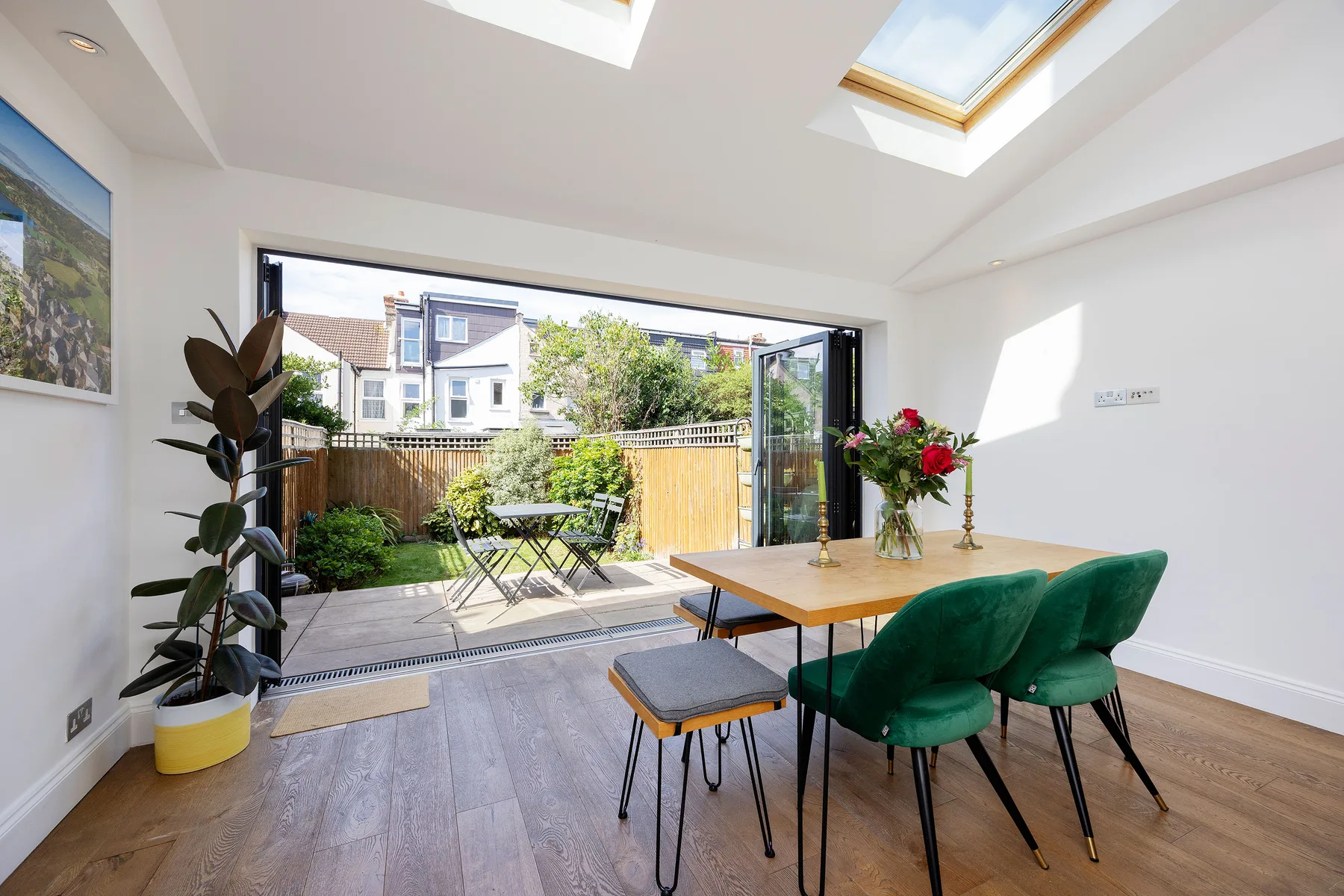 A dining area with green seating opens onto a small outdoor patio.