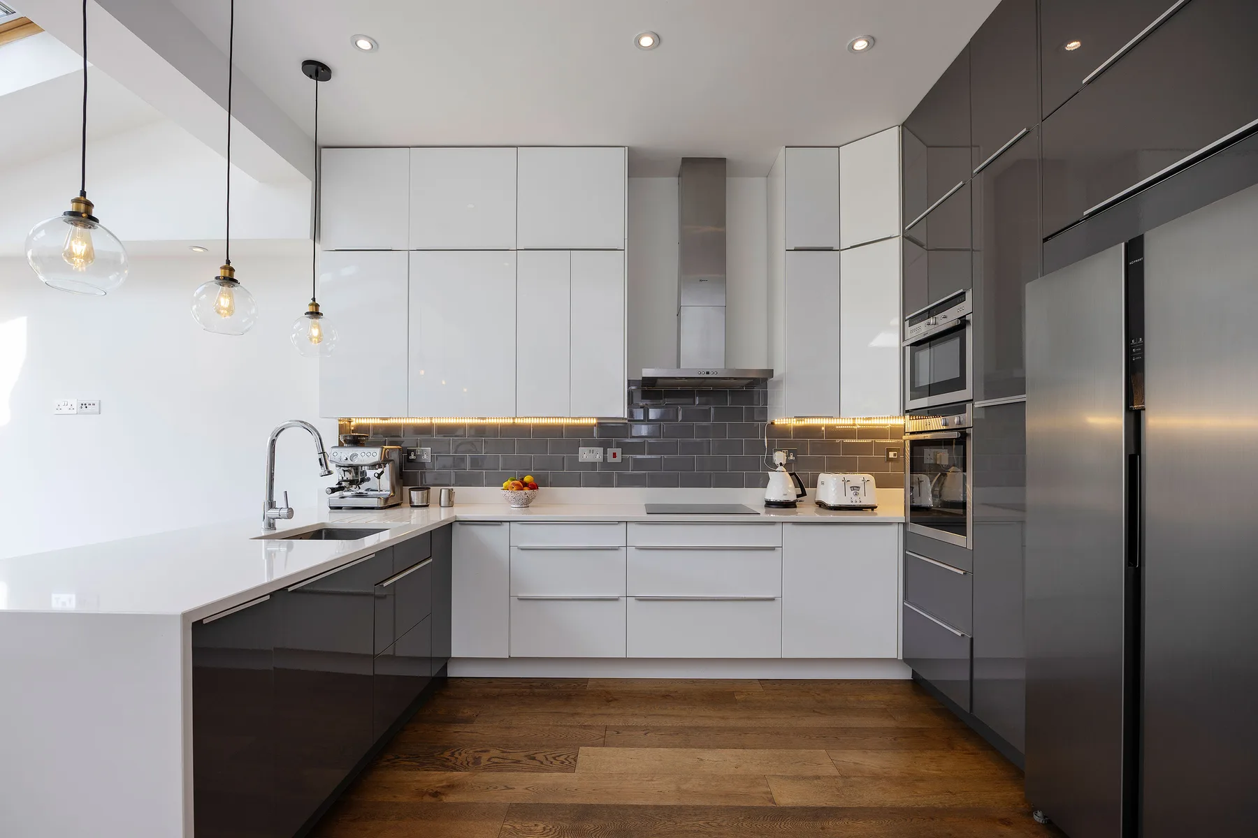 A modern kitchen with dark cabinets, white counters, and a central cooking area.