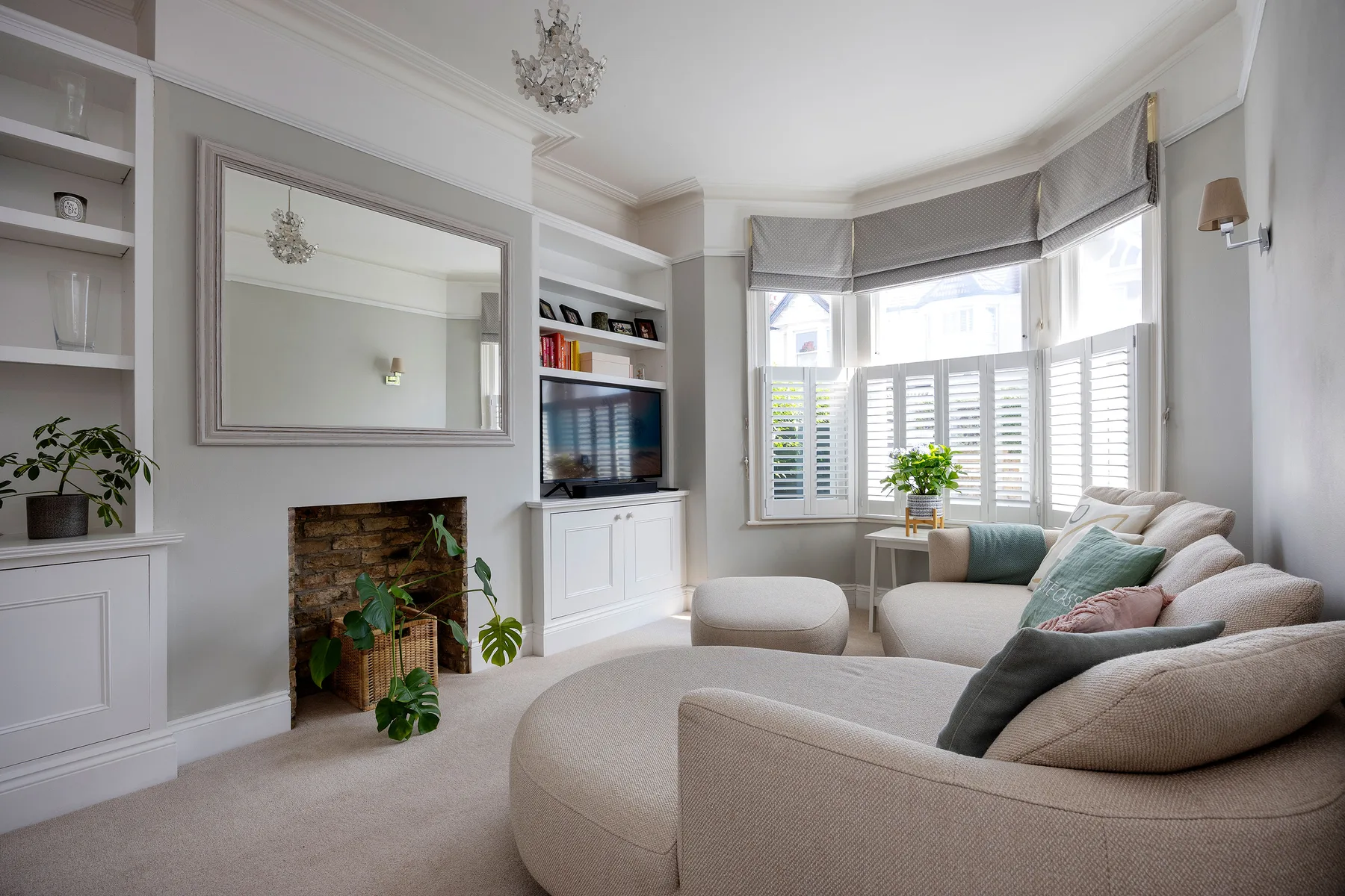 A bright living room with seating arranged beside a bay window.