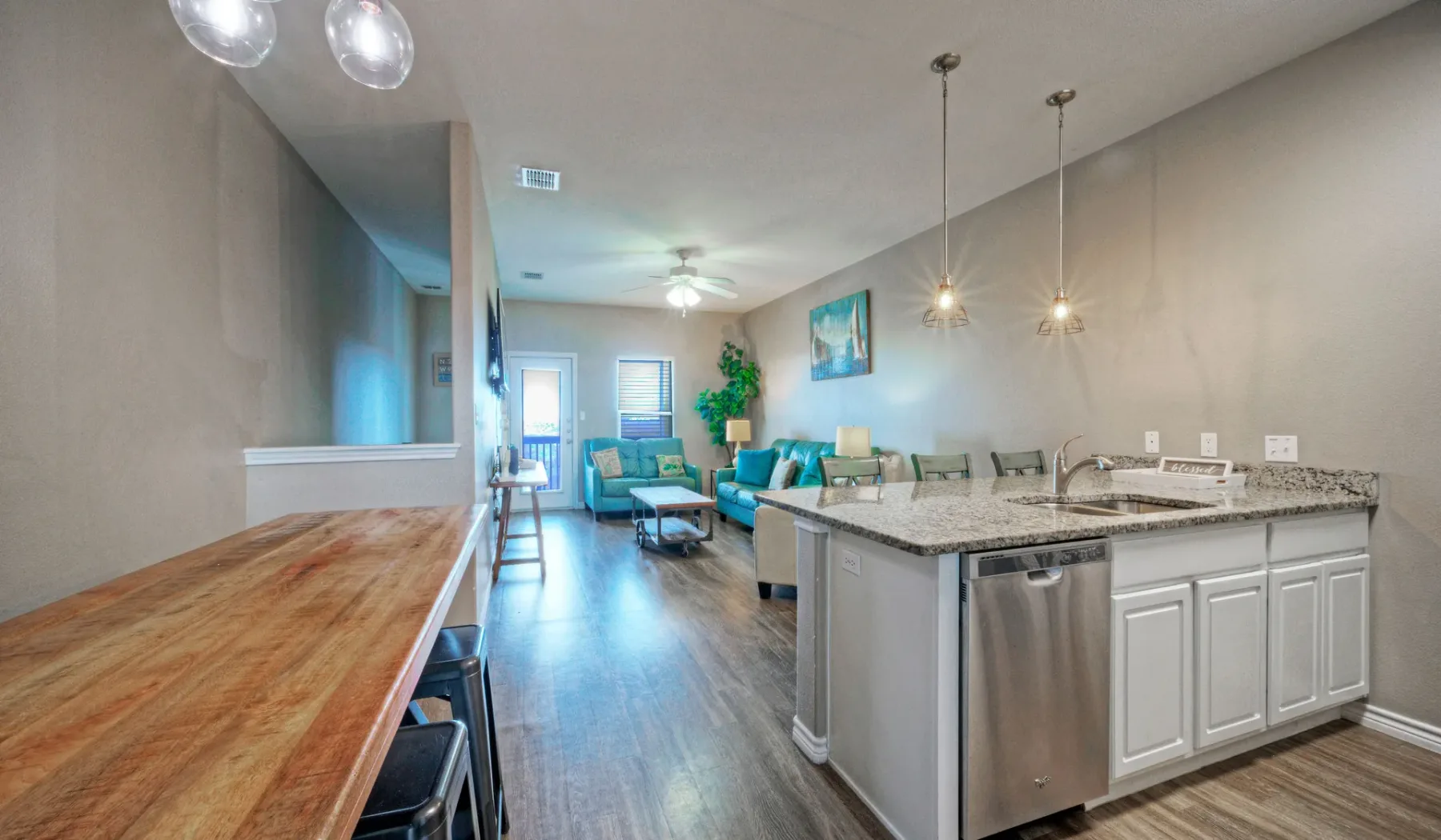 Una cocina y sala de estar de concepto abierto con una barra y asientos.