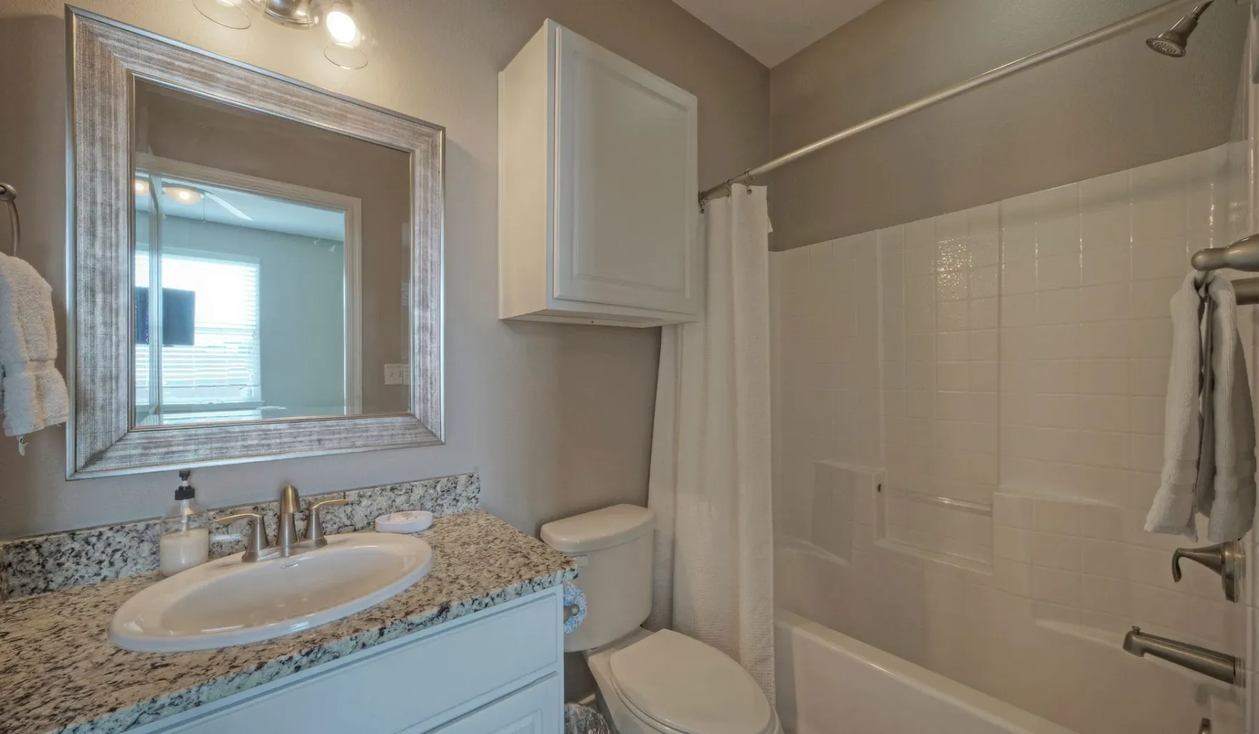 Un baño con lavabo y una bañera detrás de una cortina de ducha.