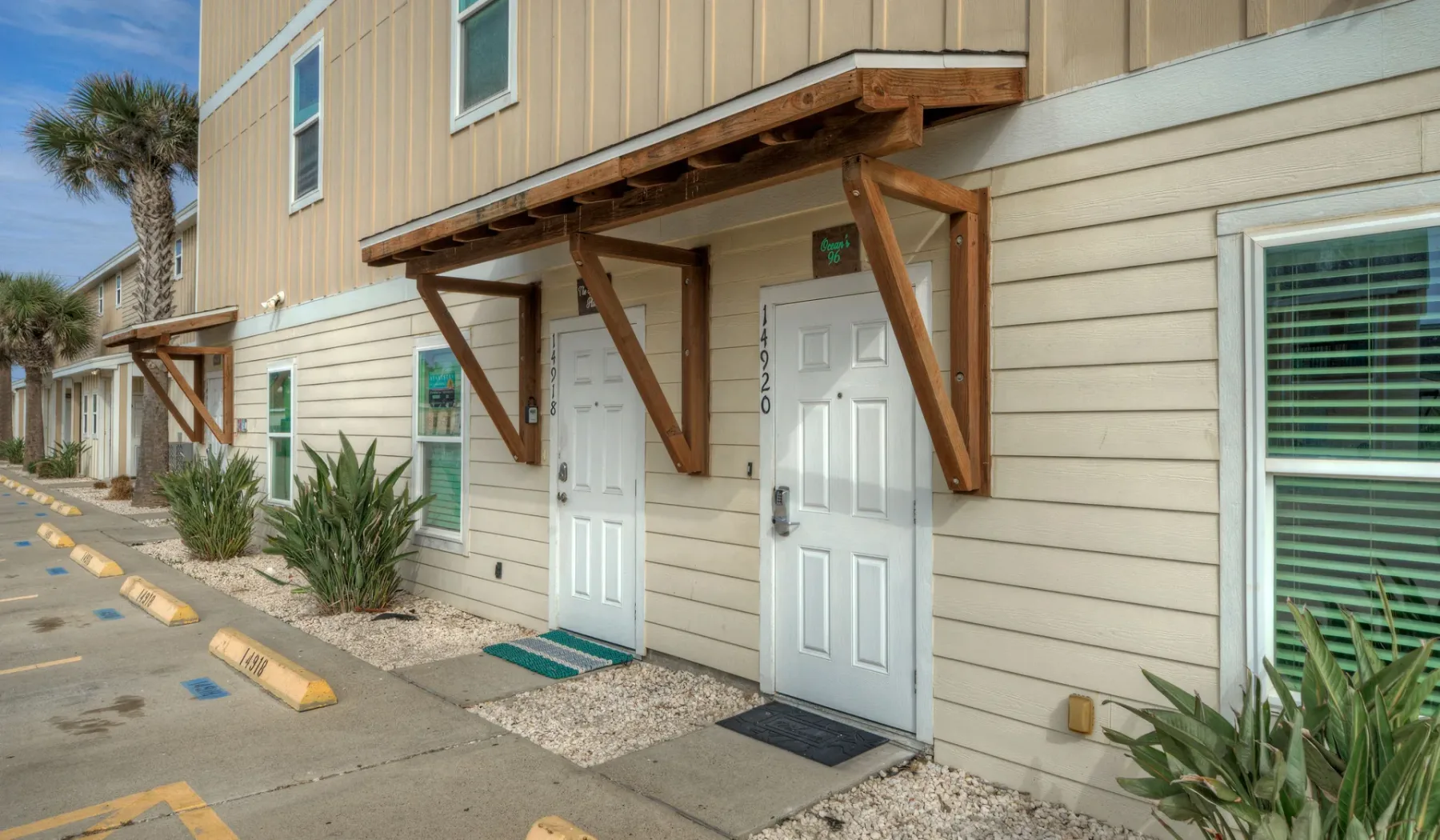 Exterior del edificio con puertas blancas bajo toldos de madera.
