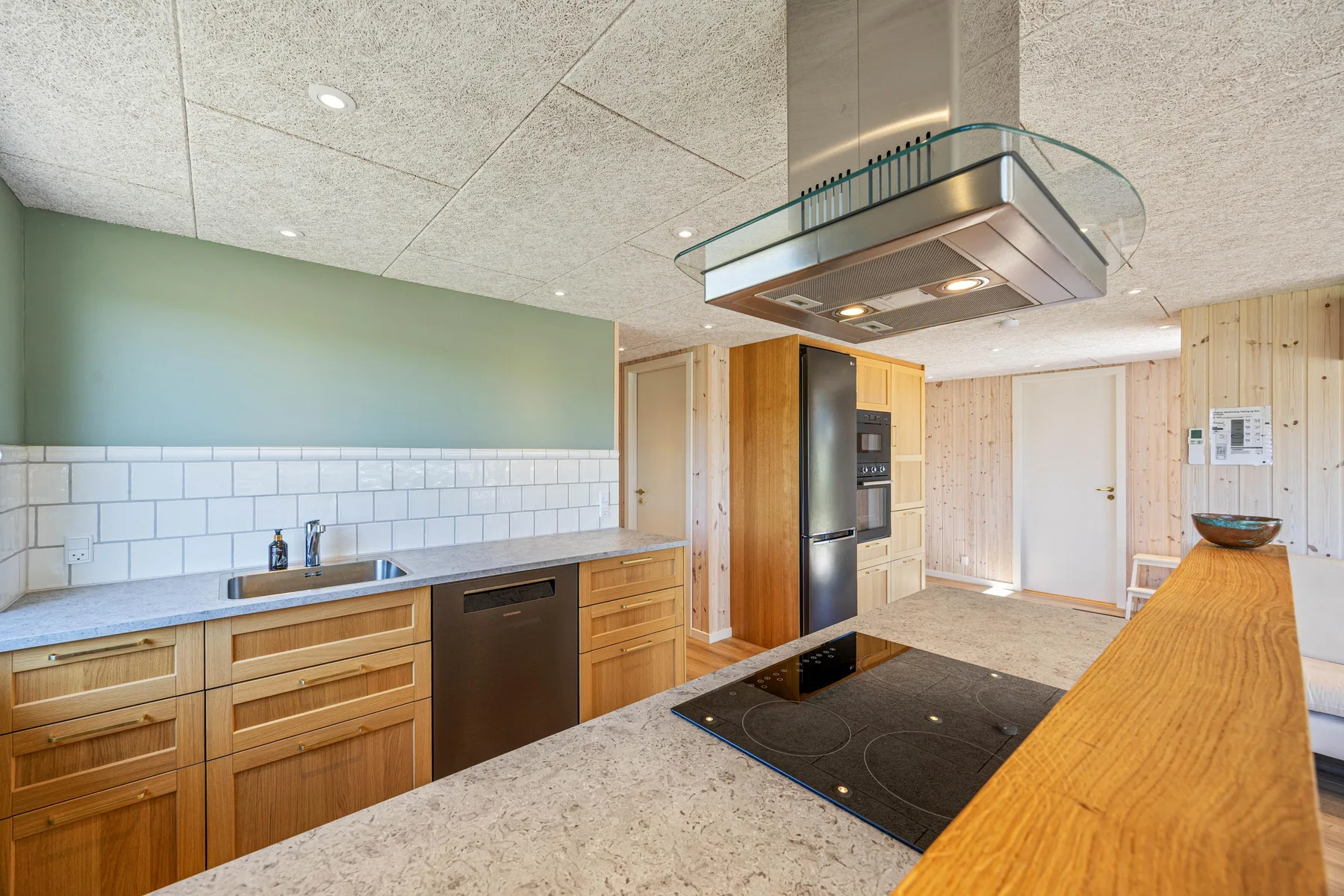Cocina con muebles de madera, una placa de cocción y una isla grande.