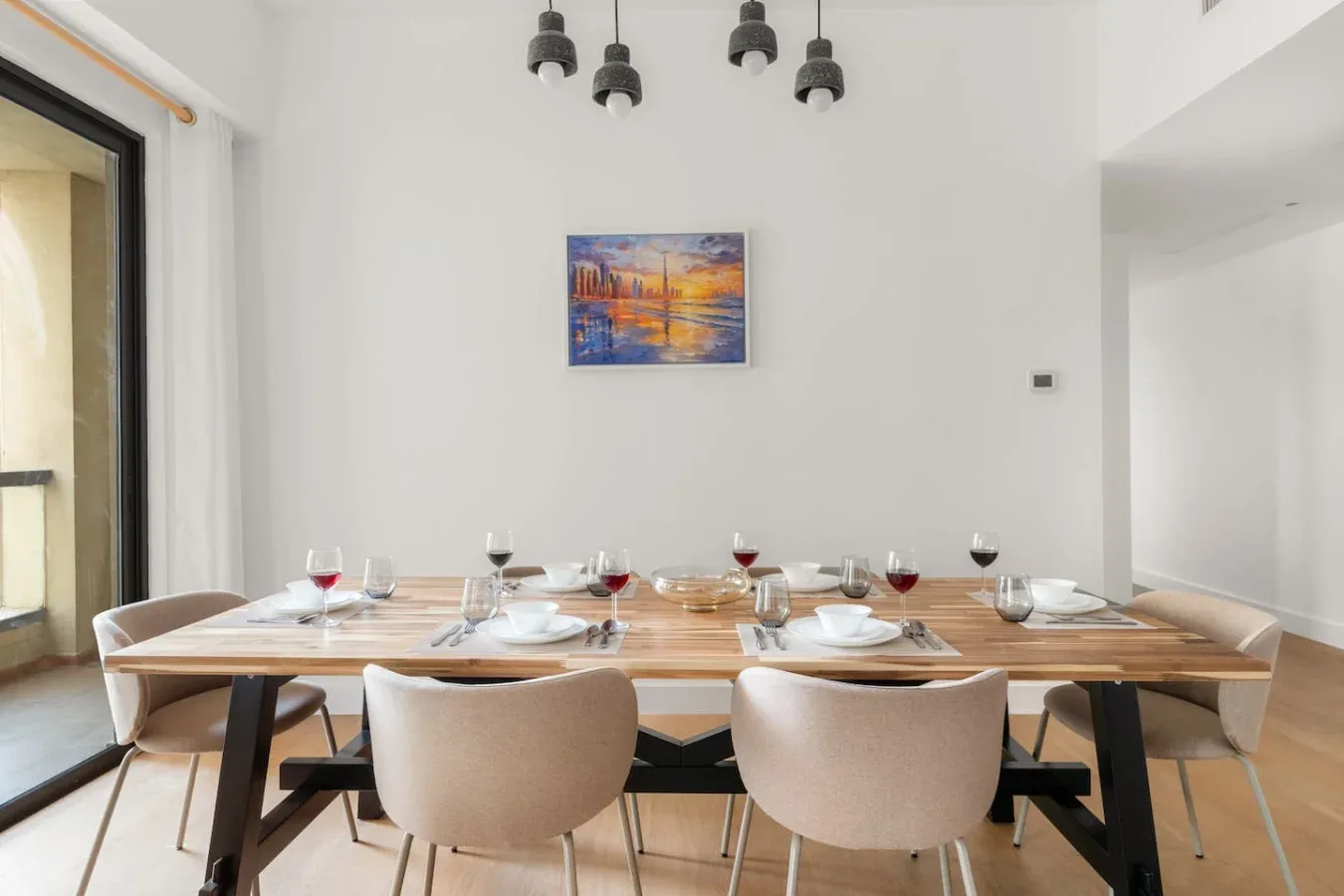 Un comedor con una mesa larga puesta con platos y vasos.