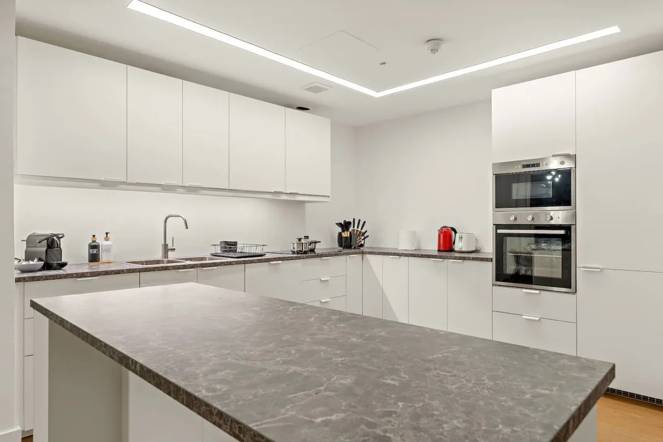Una cocina moderna con gabinetes blancos y una gran isla central.