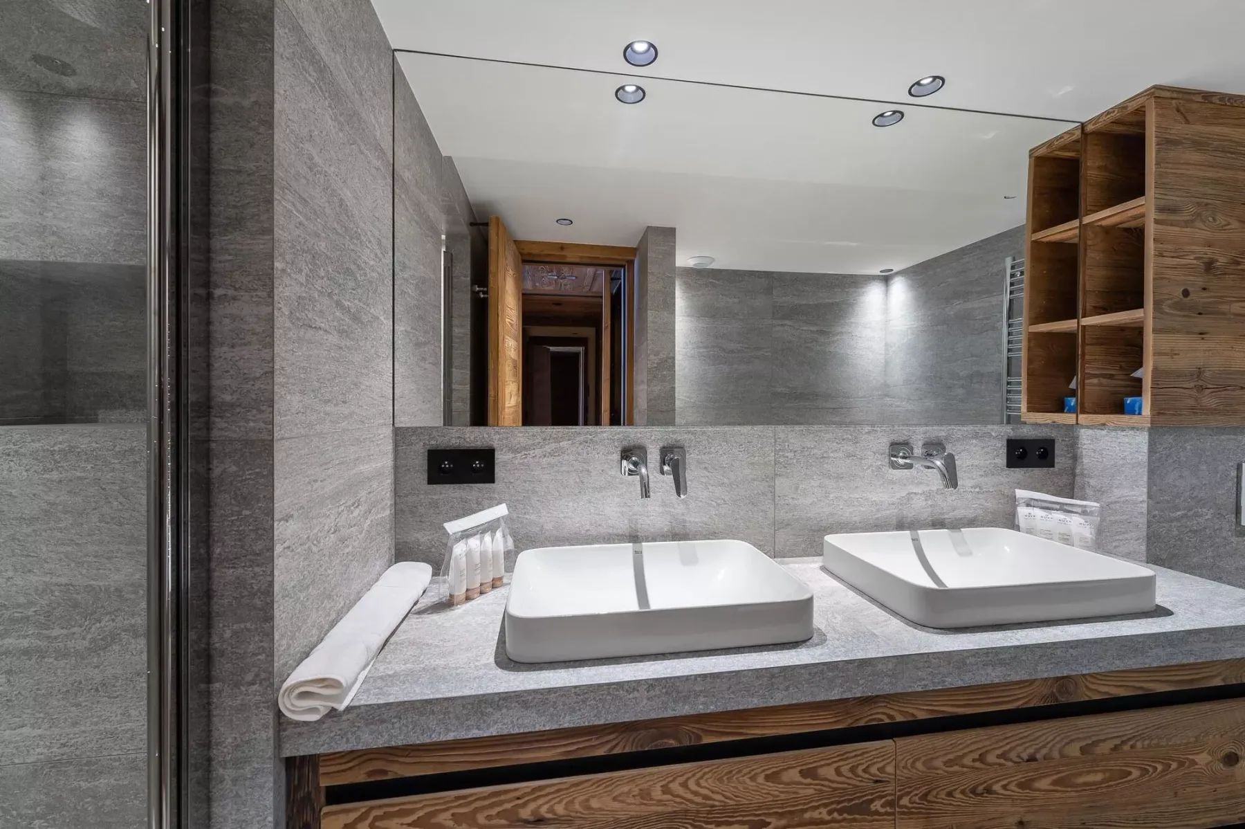 Un baño moderno con dos lavabos rectangulares bajo un espejo amplio.