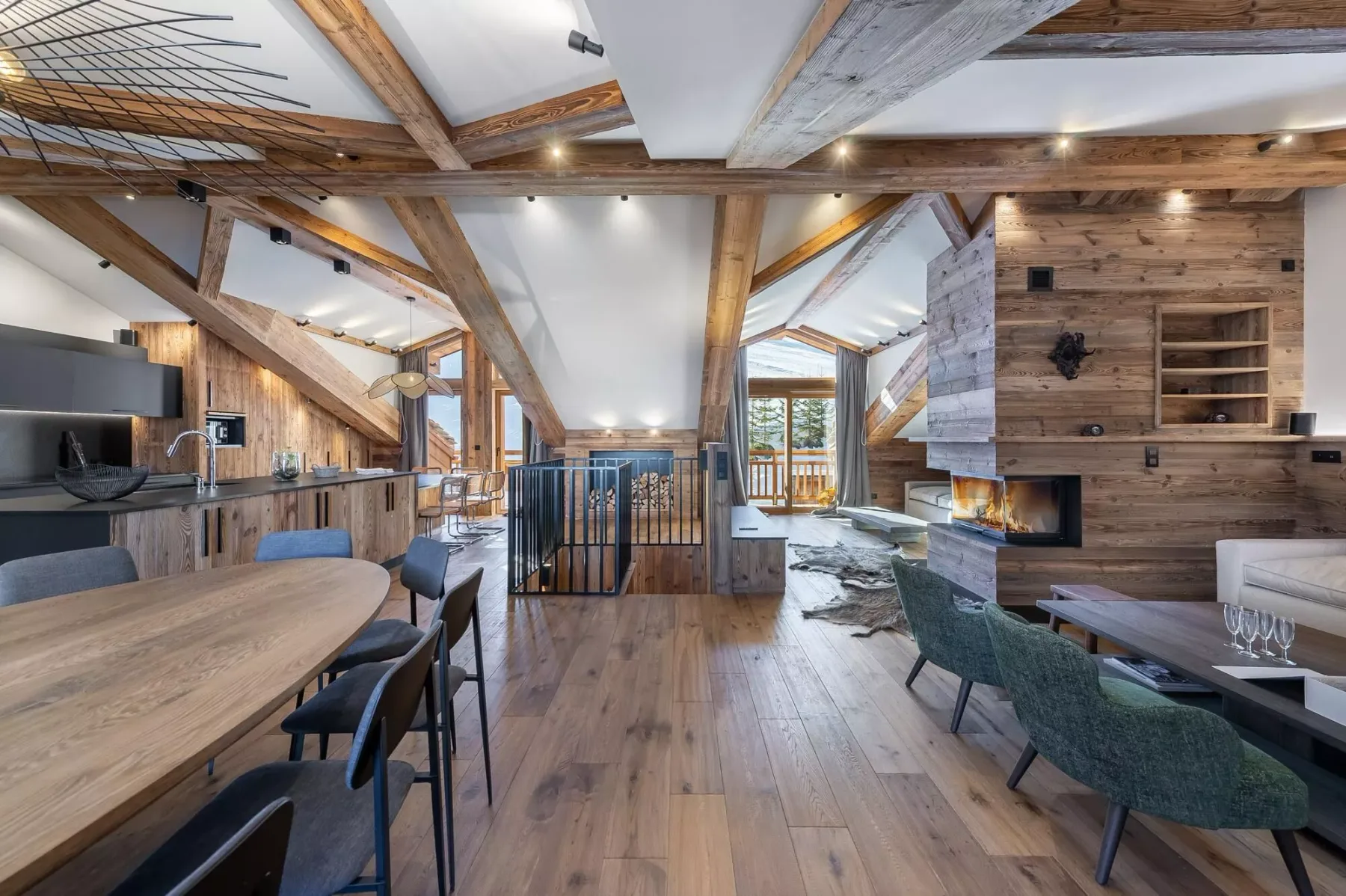 A spacious timber-framed living and dining area with a kitchen and fireplace.