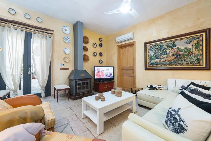 A living room with seating, a coffee table, and a framed wall tapestry.