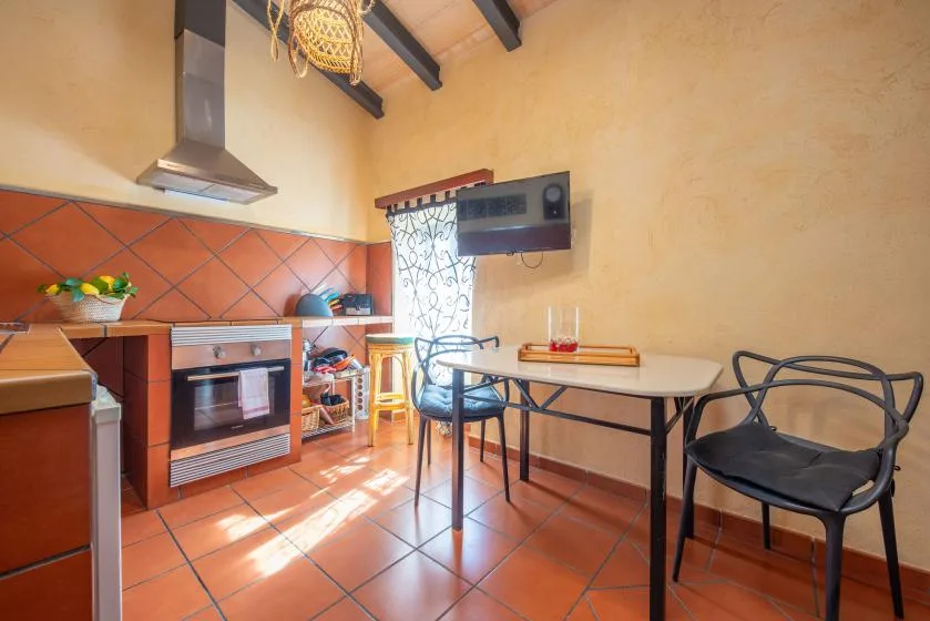 A kitchen and dining area with a table, chairs, and tiled flooring.