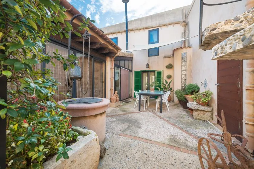 A courtyard with a small round plunge pool, potted plants, and outdoor seating.