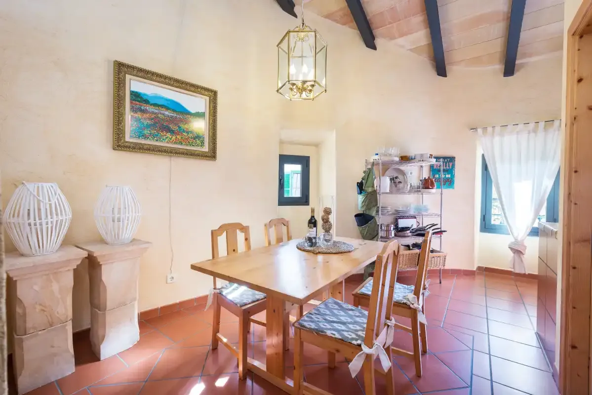A dining area with a wooden table and chairs beside a bright window.