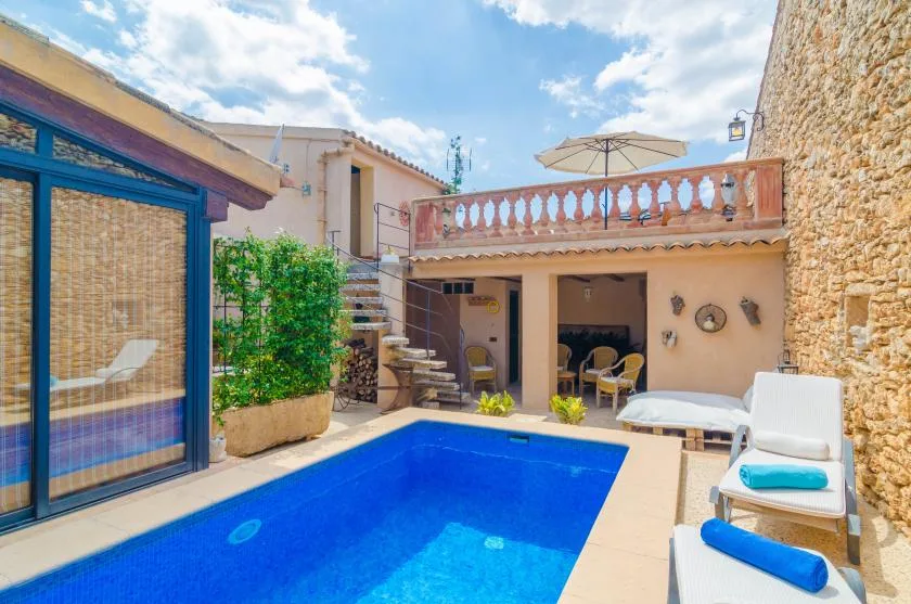 Outdoor pool area with a raised terrace and seating.