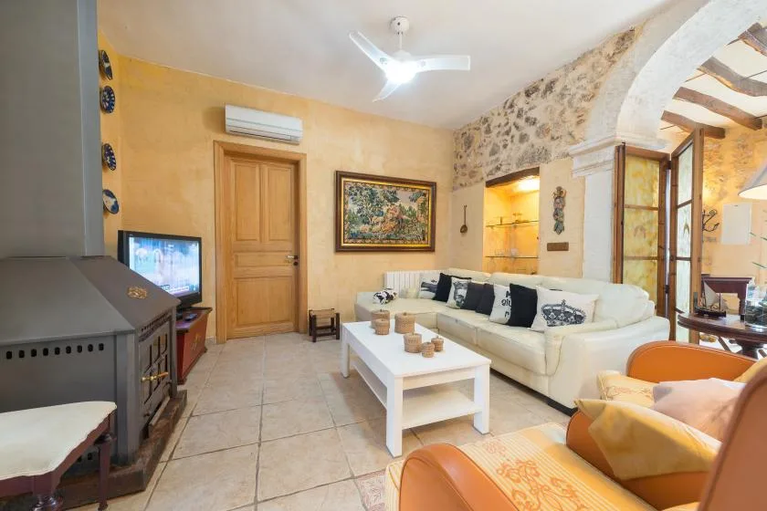 A living room with cream seating, a white coffee table, and a stone archway.