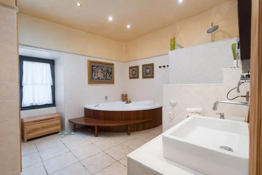 A bathroom with a large bathtub and a sink in the foreground.