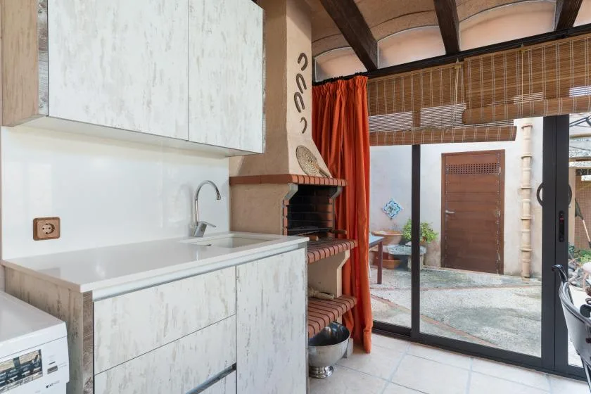A kitchen opens onto a patio through a wide glass sliding door.