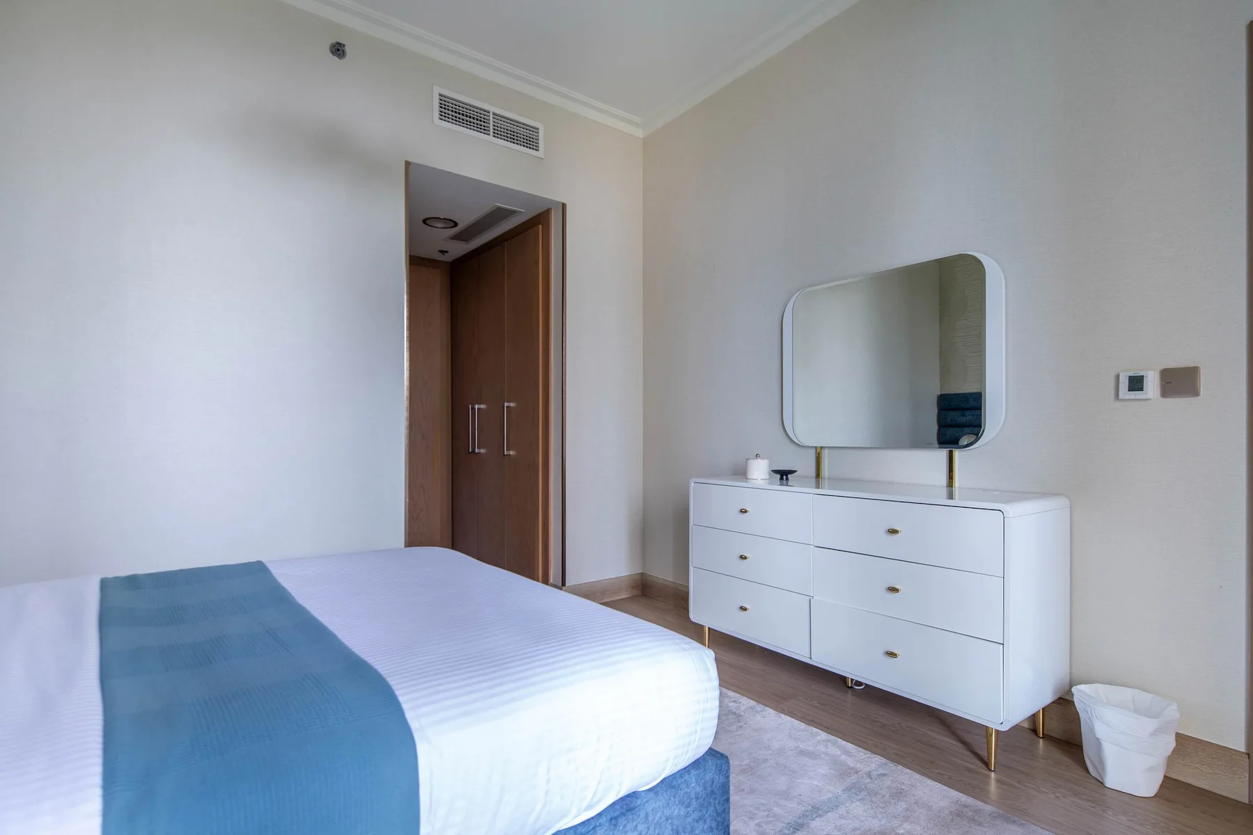 Bedroom with a bed, dresser, and wall mirror.