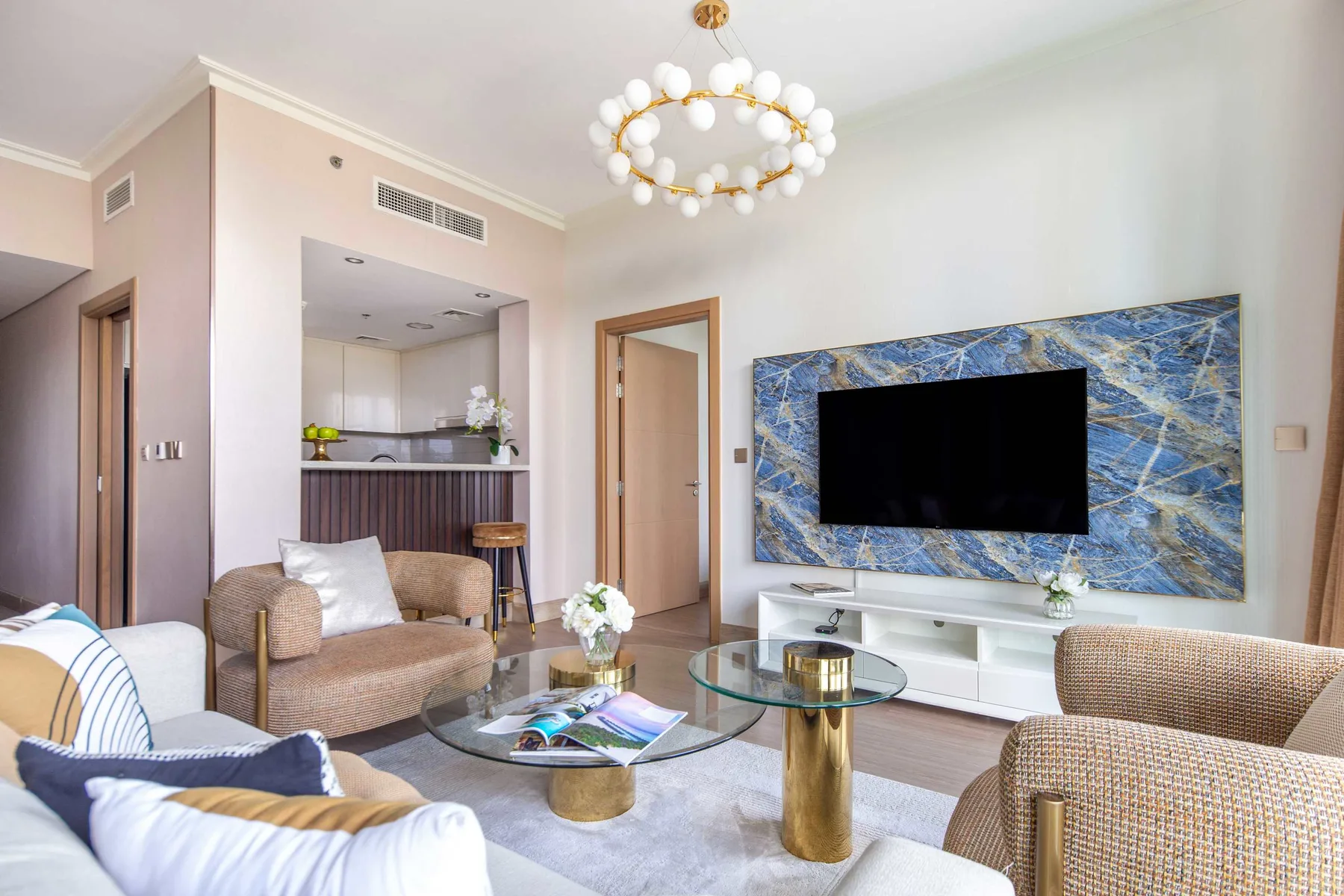 Una sala luminosa con un televisor sobre un mueble blanco.