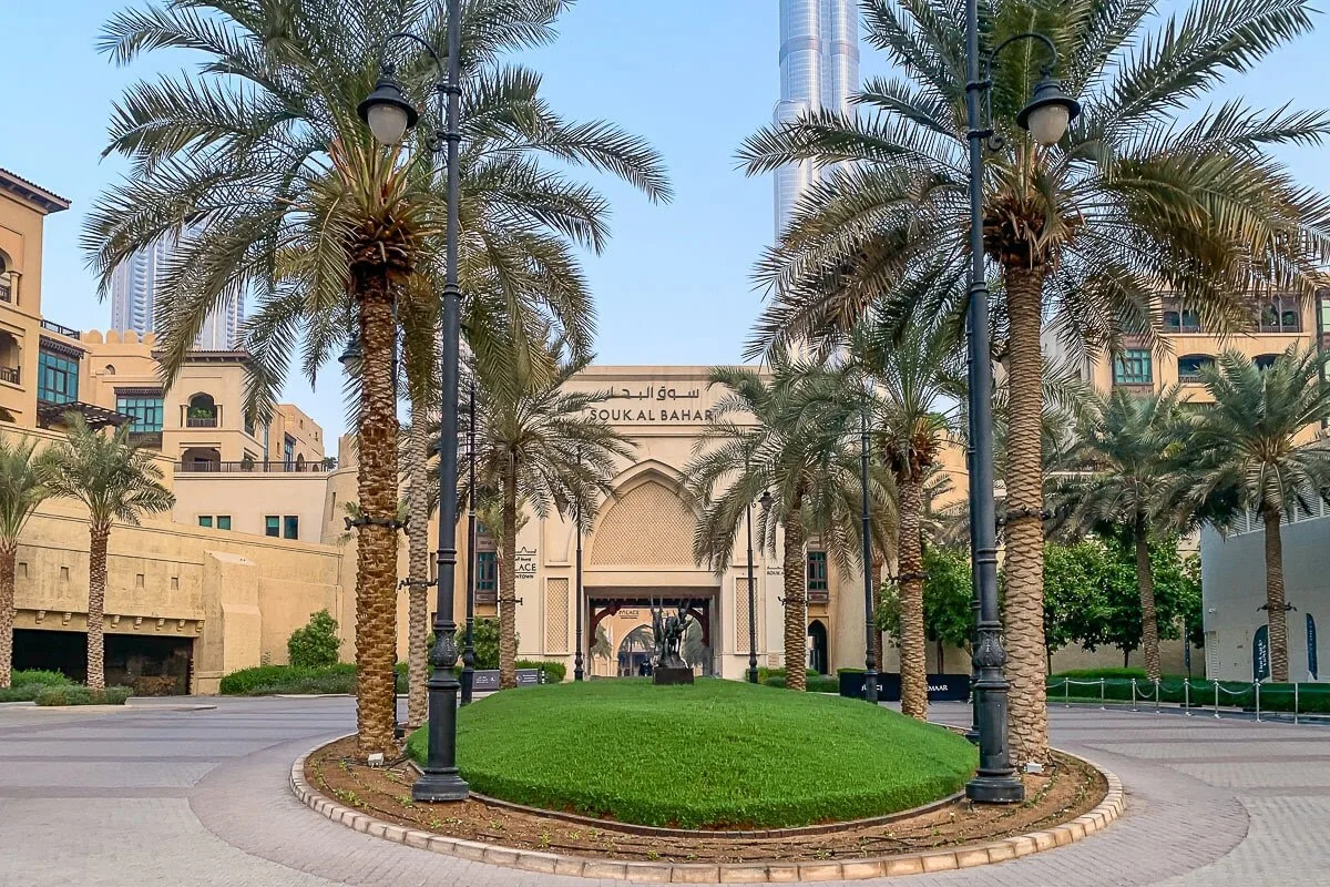 A landscaped courtyard with palm trees and a large arched entrance.