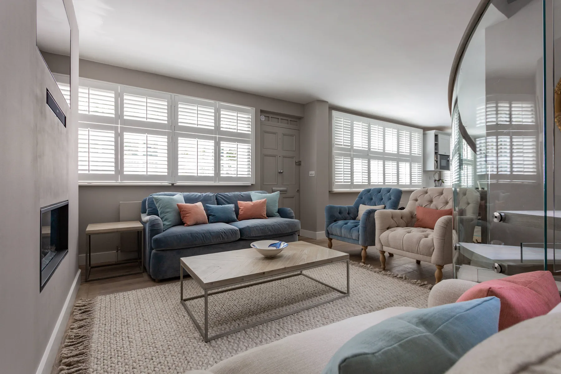A bright living room with seating arranged around a low coffee table.