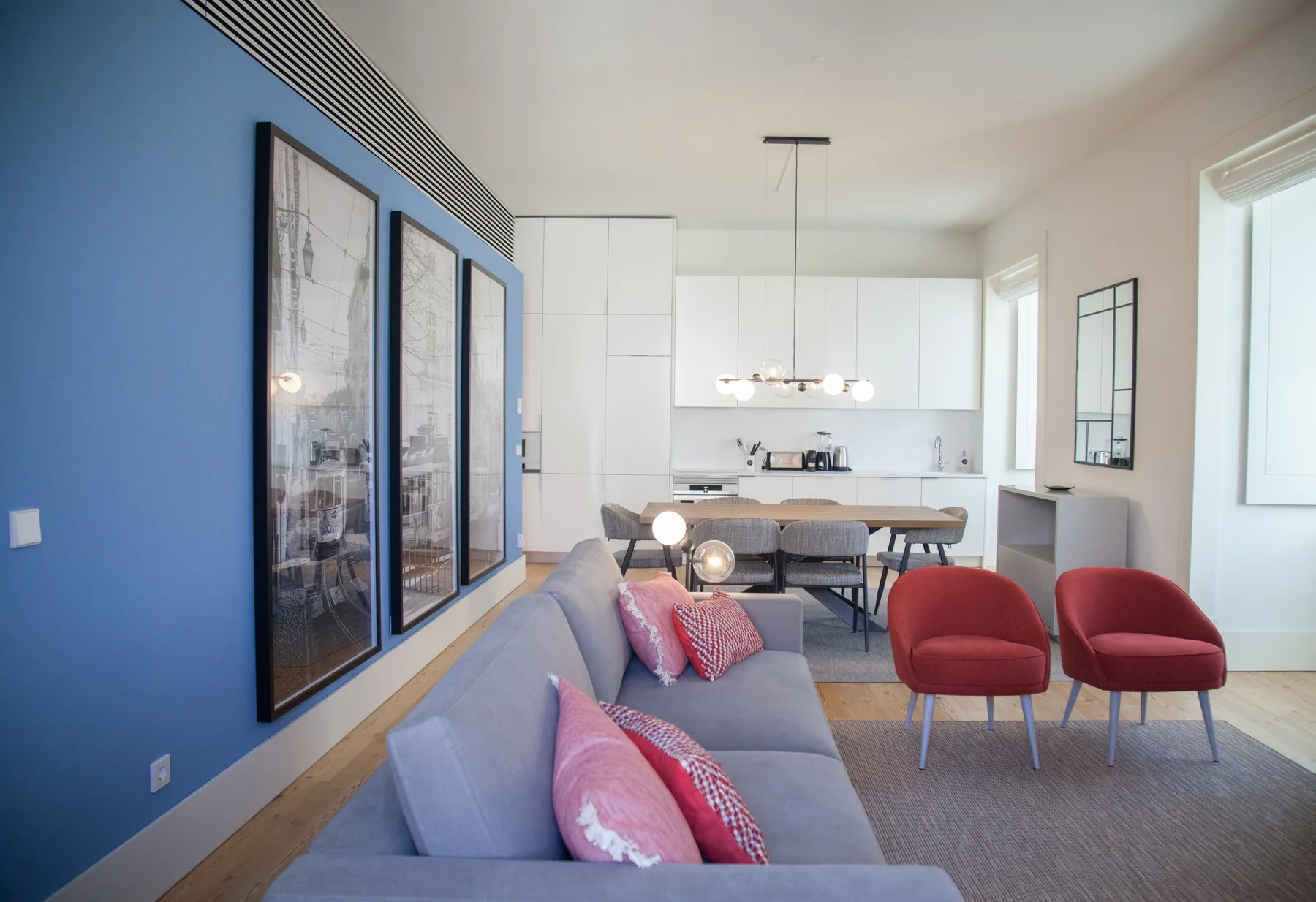 Una sala luminosa con asientos y una cocina abierta.