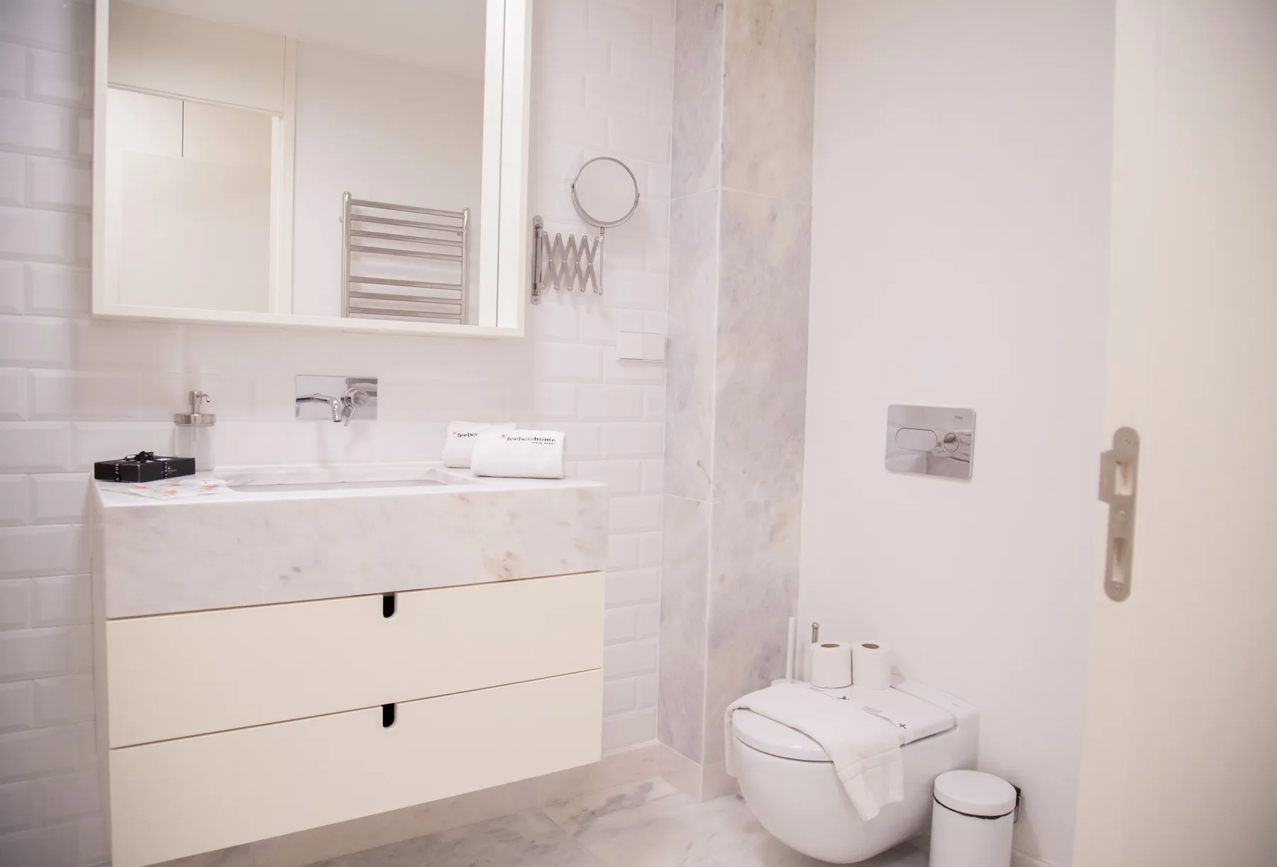 Un baño luminoso con un lavabo suspendido y un inodoro.