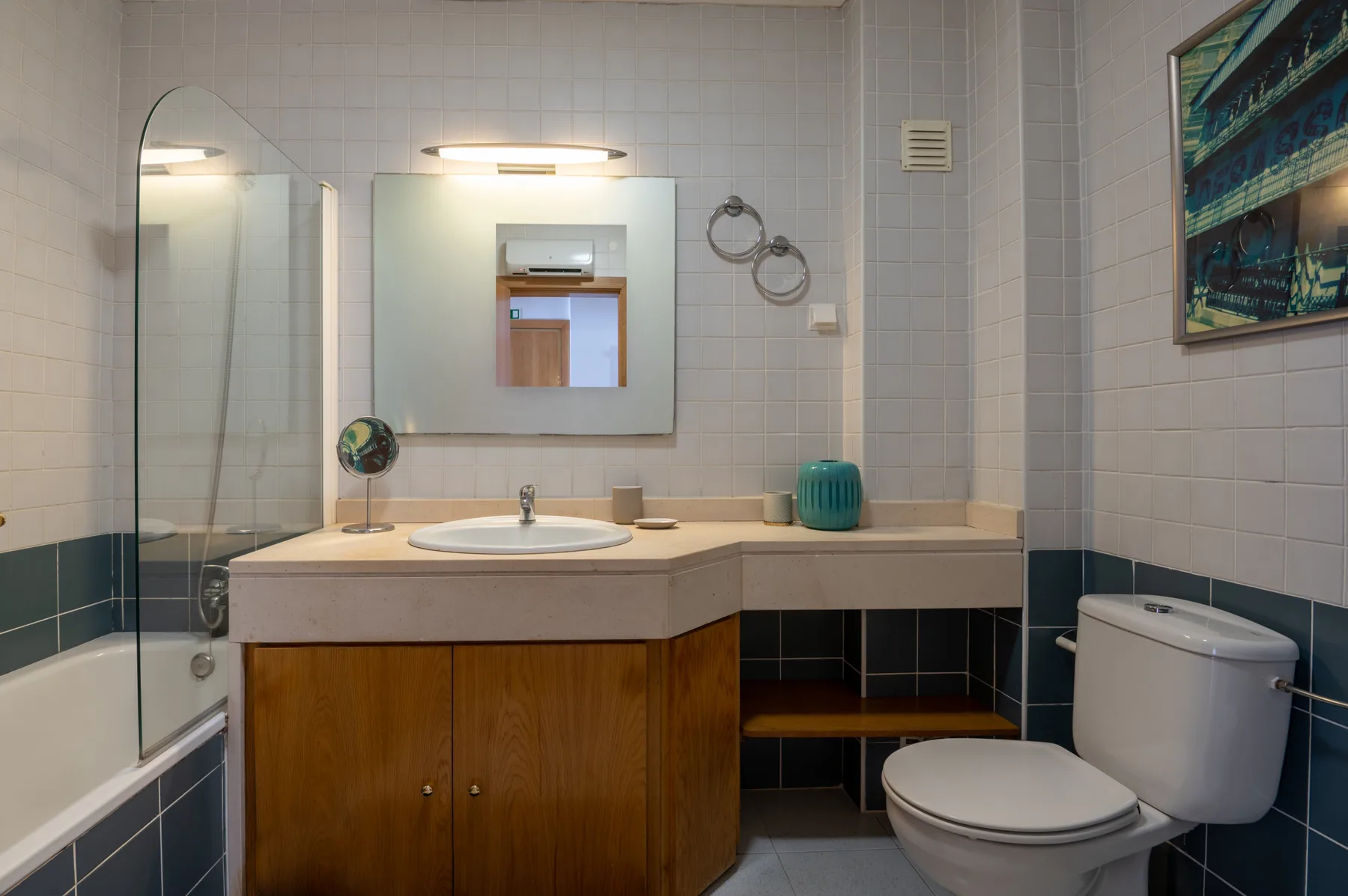 A tiled bathroom with a sink, mirror, and toilet.