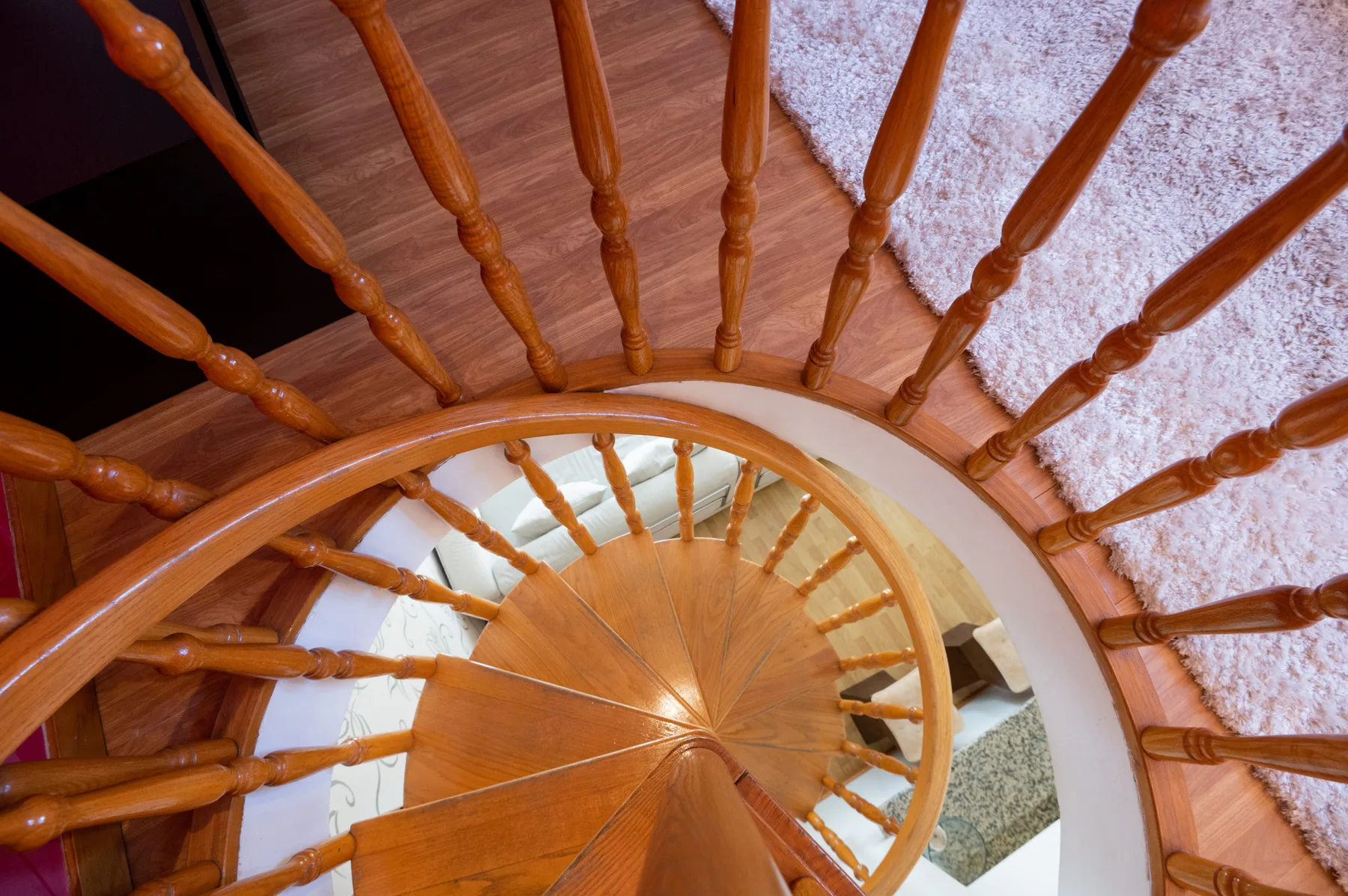 A curved wooden staircase with railings winds around an open central space.