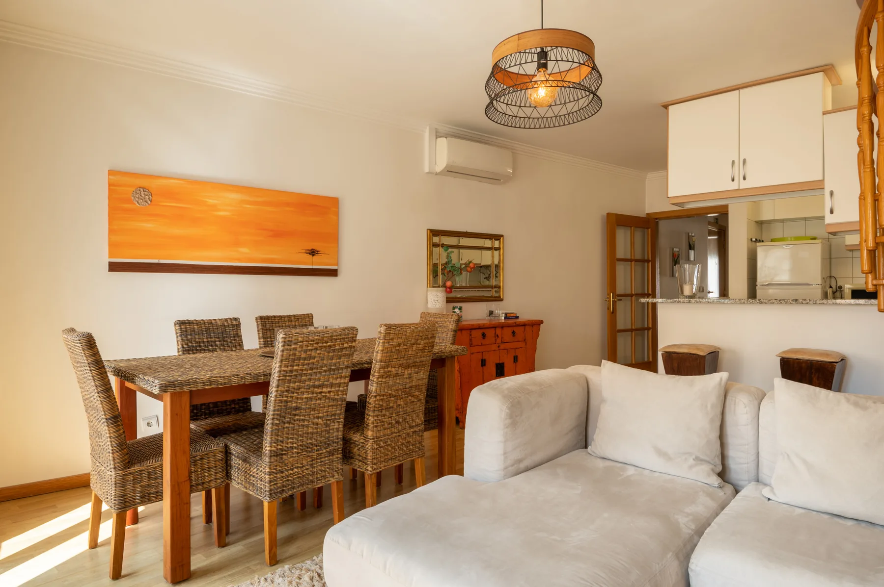 Una sala de estar y comedor con un sofá junto a una mesa de comedor de madera.