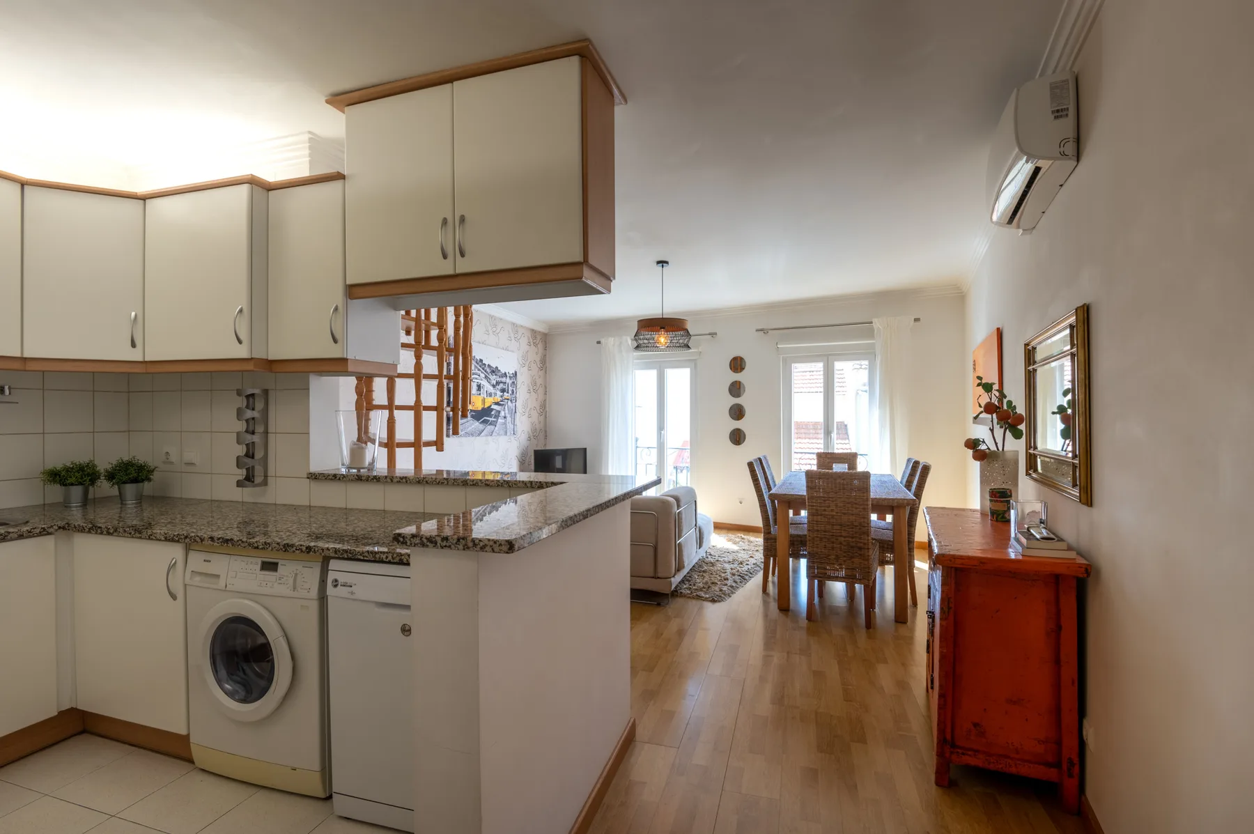 Una cocina abierta al comedor con una mesa de madera y sillas.