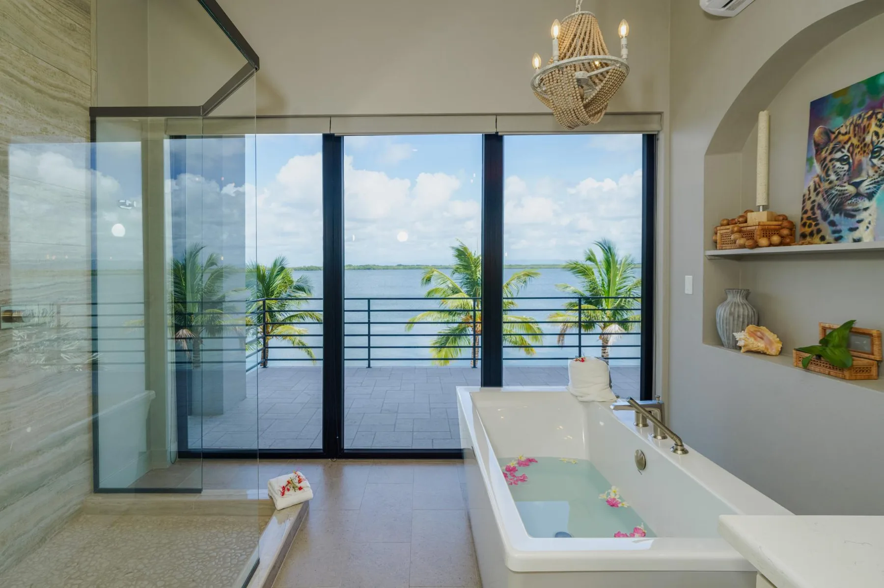 A bright bathroom opens onto a balcony with ocean views.