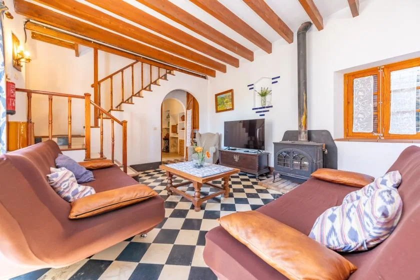 A living room with seating, a television, and a checkered tile floor.