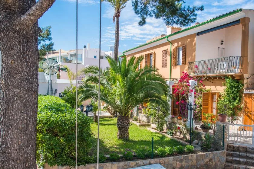 A landscaped garden with palm trees and a peach-colored building.