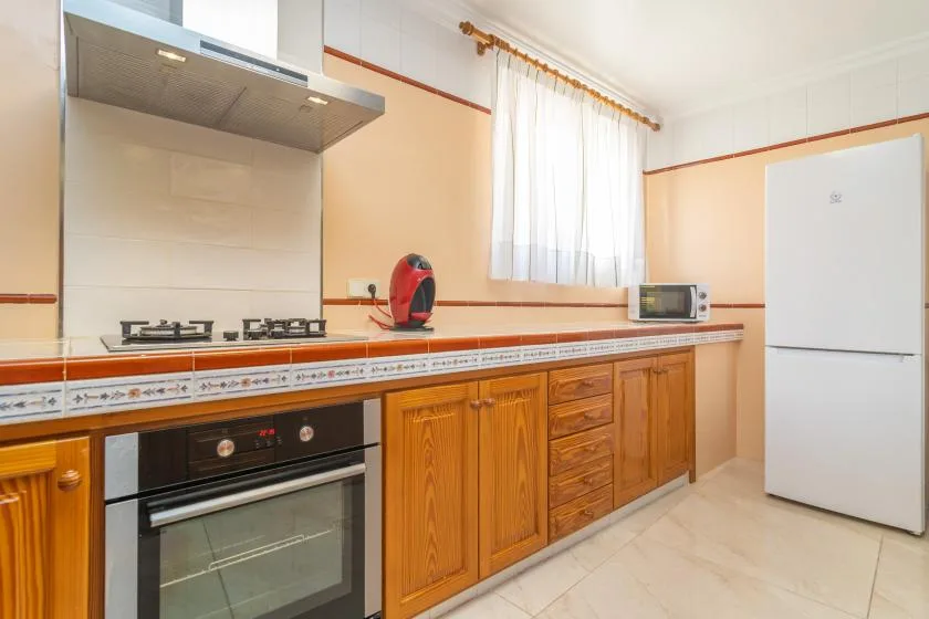A kitchen with a countertop, stovetop, oven, microwave, and refrigerator.