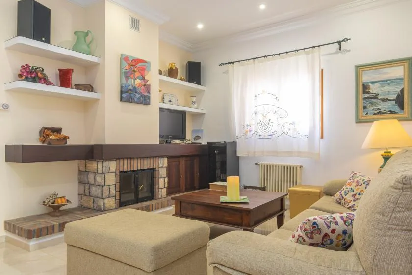 A living room with seating around a coffee table and a stone fireplace.