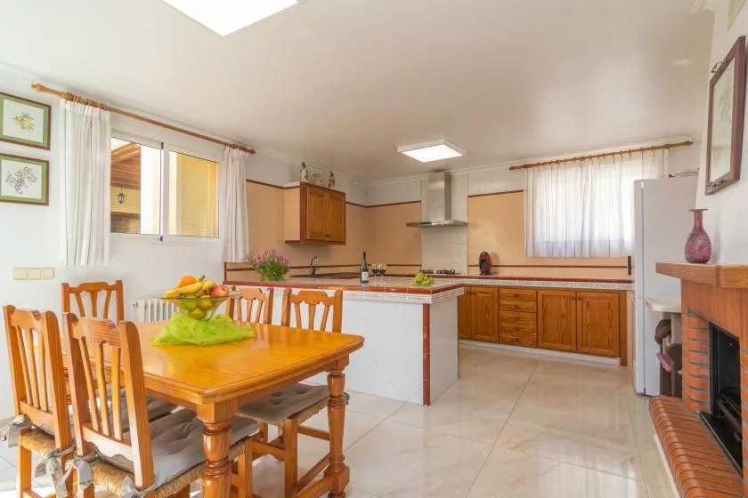 A bright kitchen and dining area with a wooden table and counters.