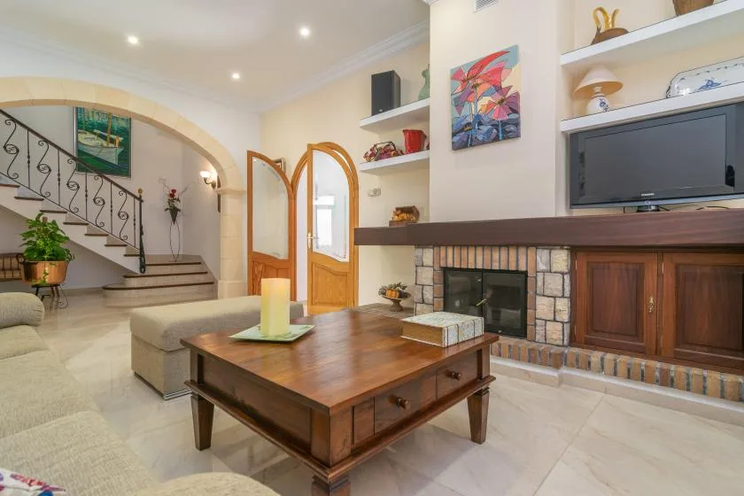 A living room with a wooden coffee table, fireplace, and built-in shelving.