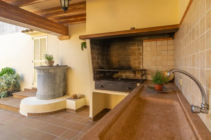 An outdoor cooking area with a built-in grill and a long counter.