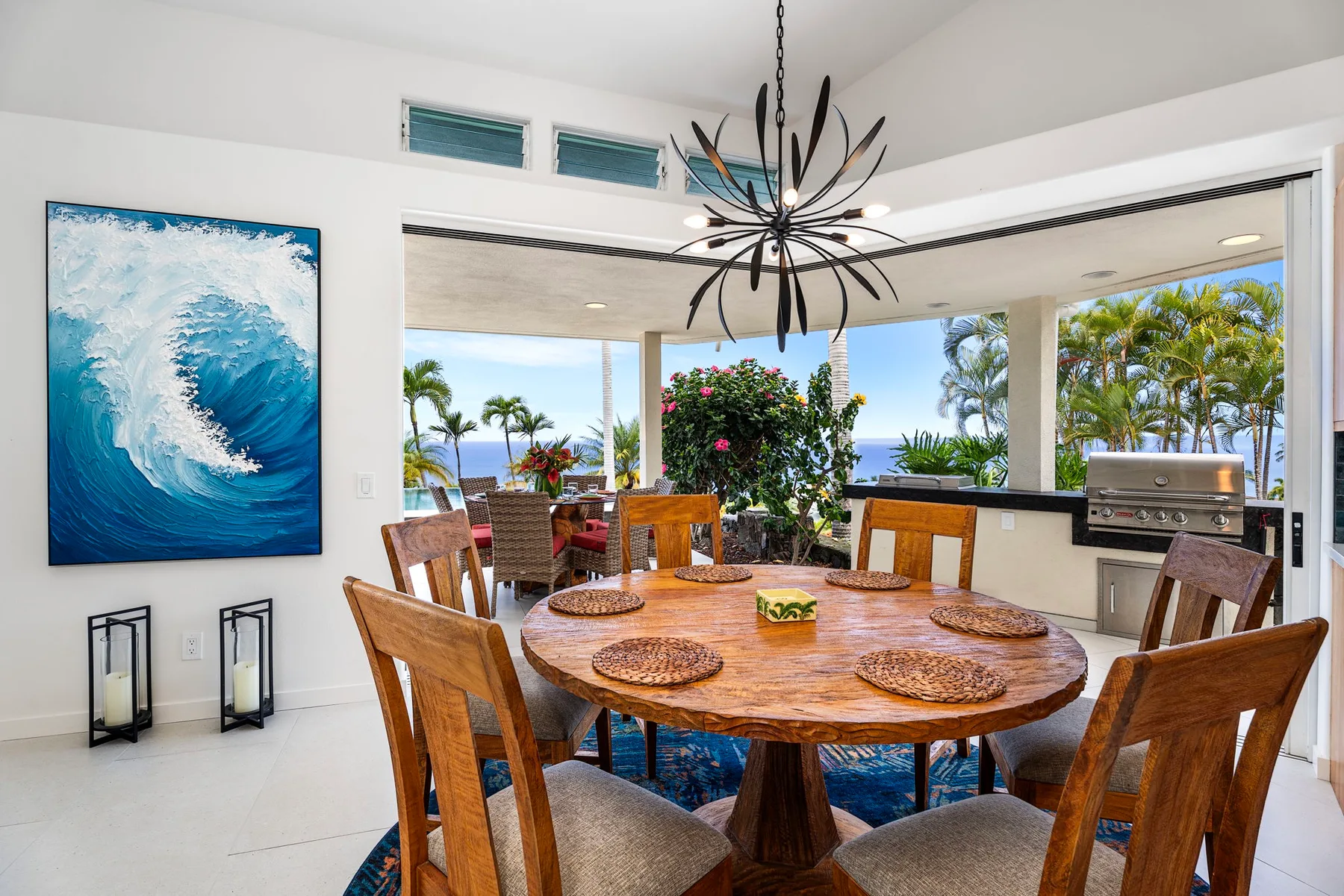 Comedor con una mesa de madera, asientos y vistas al mar.