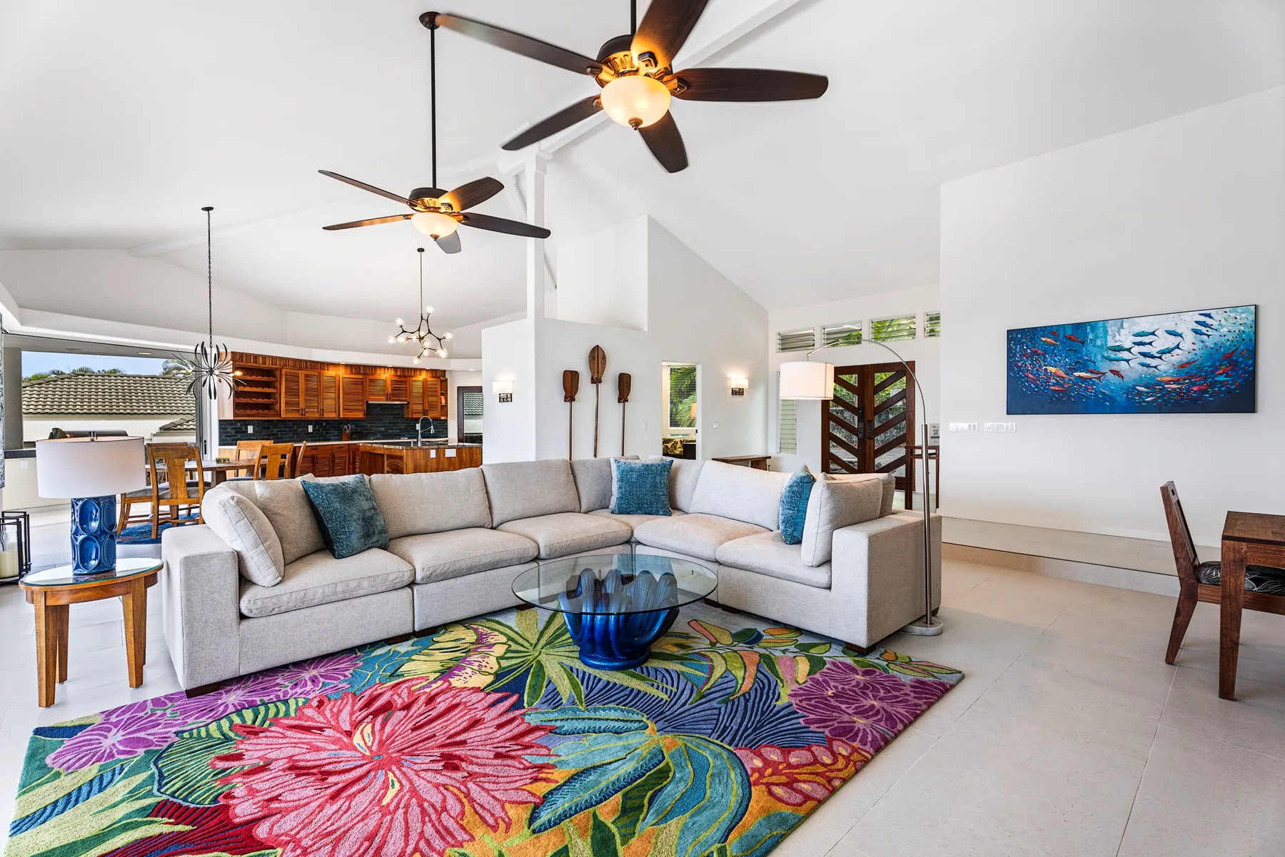 Una sala luminosa con una zona de asientos y una alfombra floral colorida.