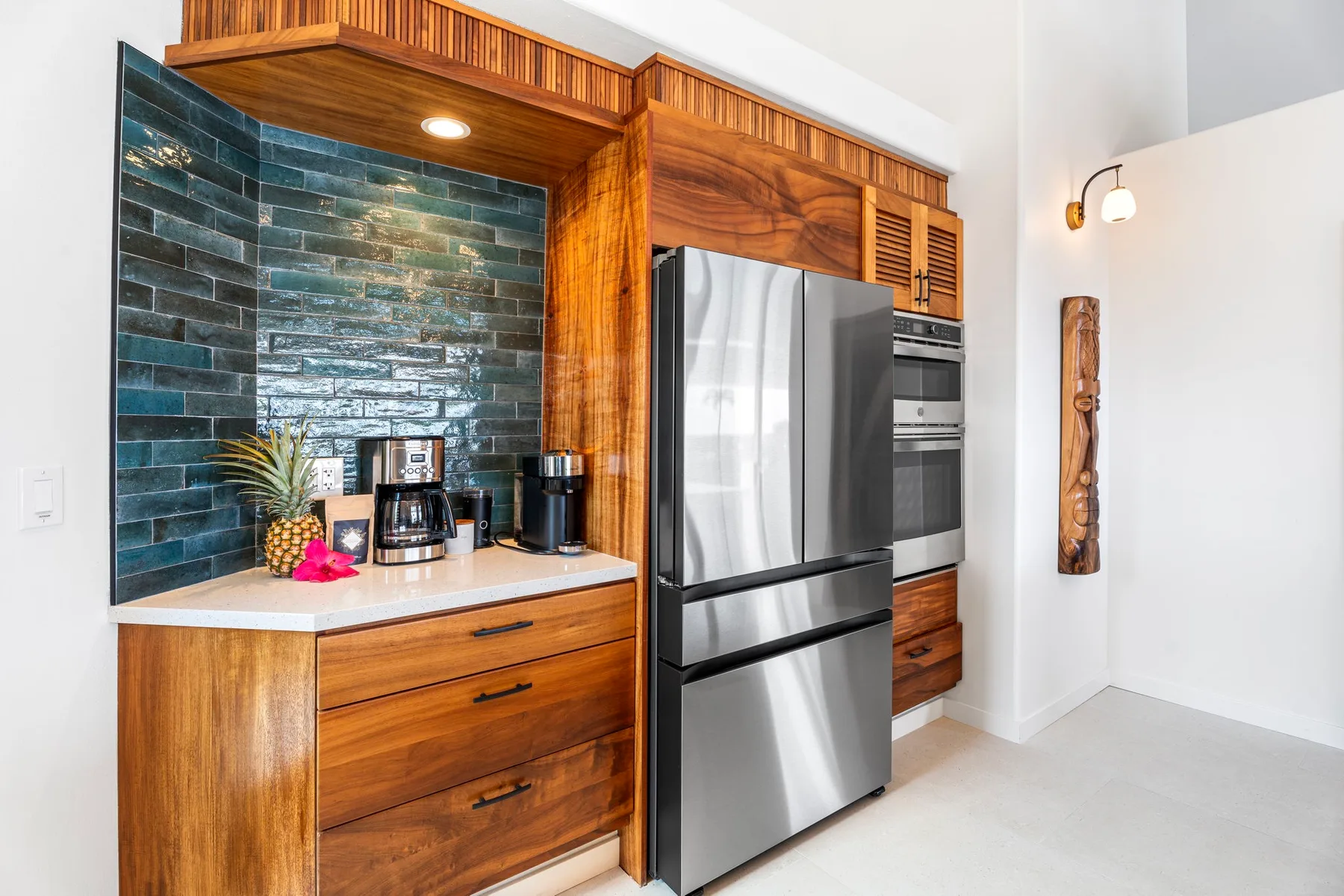 Una cocina con gabinetes de madera, electrodomésticos de acero inoxidable y un salpicadero de azulejos.